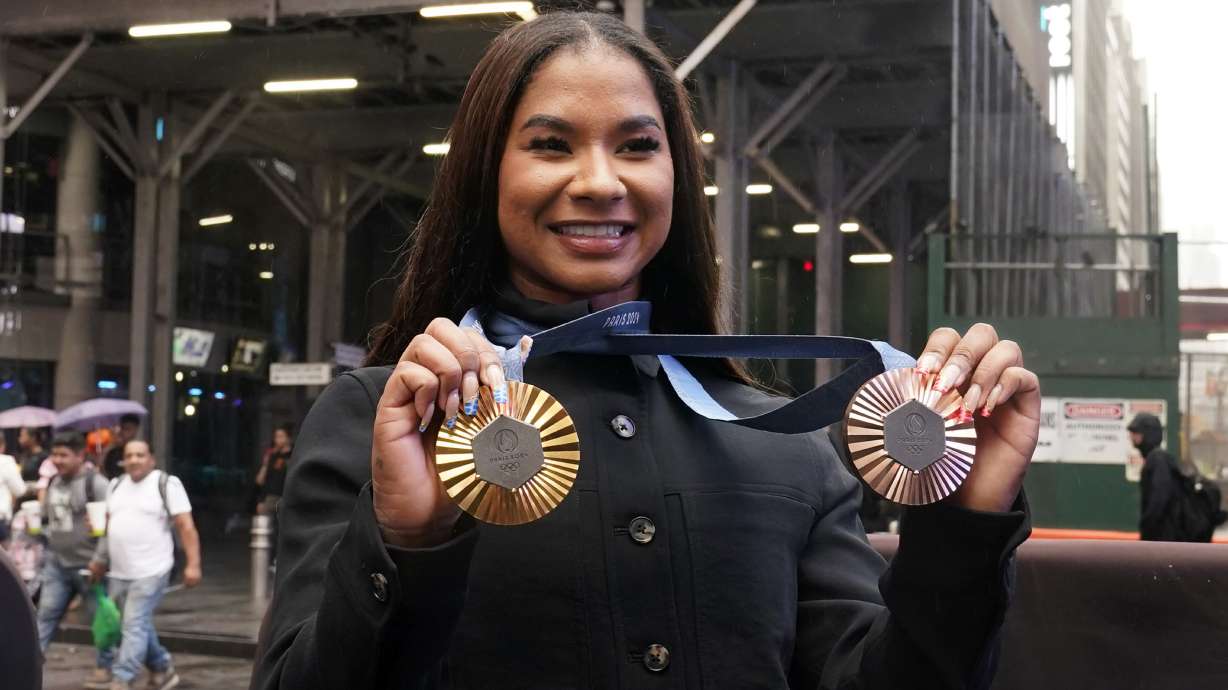 Two-time U.S. Olympic gymnast medalist Jordan Chiles shows her medals after ringing the closing bell at the Nasdaq MarketSite, in New York's Times Square, Thursday, Aug. 8, 2024.