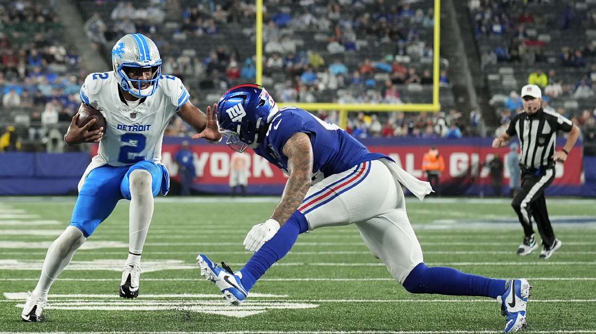 Detroit Lions quarterback Hendon Hooker (2) carries the ball against New York Giants linebacker Darrian Beavers (43) during the third quarter of an NFL football game, Thursday, Aug. 8, 2024, in East Rutherford, N.J.