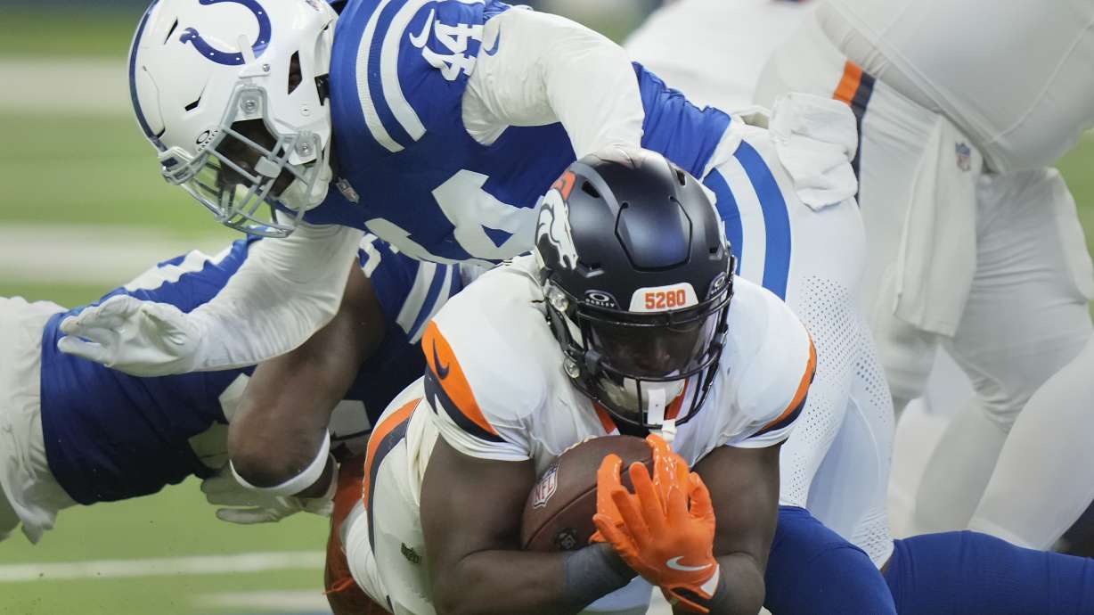 Denver Broncos running back Javonte Williams (33) is tackled by Indianapolis Colts linebacker Zaire Franklin (44) during the first quarter of a preseason NFL football game, Sunday, Aug. 11, 2024, in Westfield, Ind.