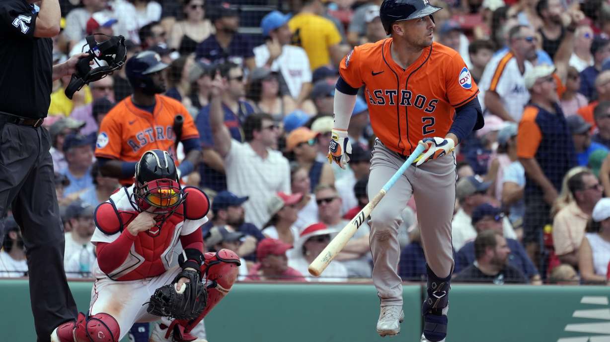 Houston Astros' Alex Bregman (2) watches his three-run home run in front of Boston Red Sox catcher Connor Wong during the fifth inning of a baseball game, Sunday, Aug. 11, 2024, in Boston.