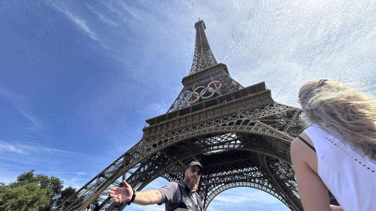 Police evacuate the area around the Eiffel Tower after a man was seen climbing the historic landmark, during the 2024 Summer Olympics, Sunday, Aug. 11, 2024, in Paris France.