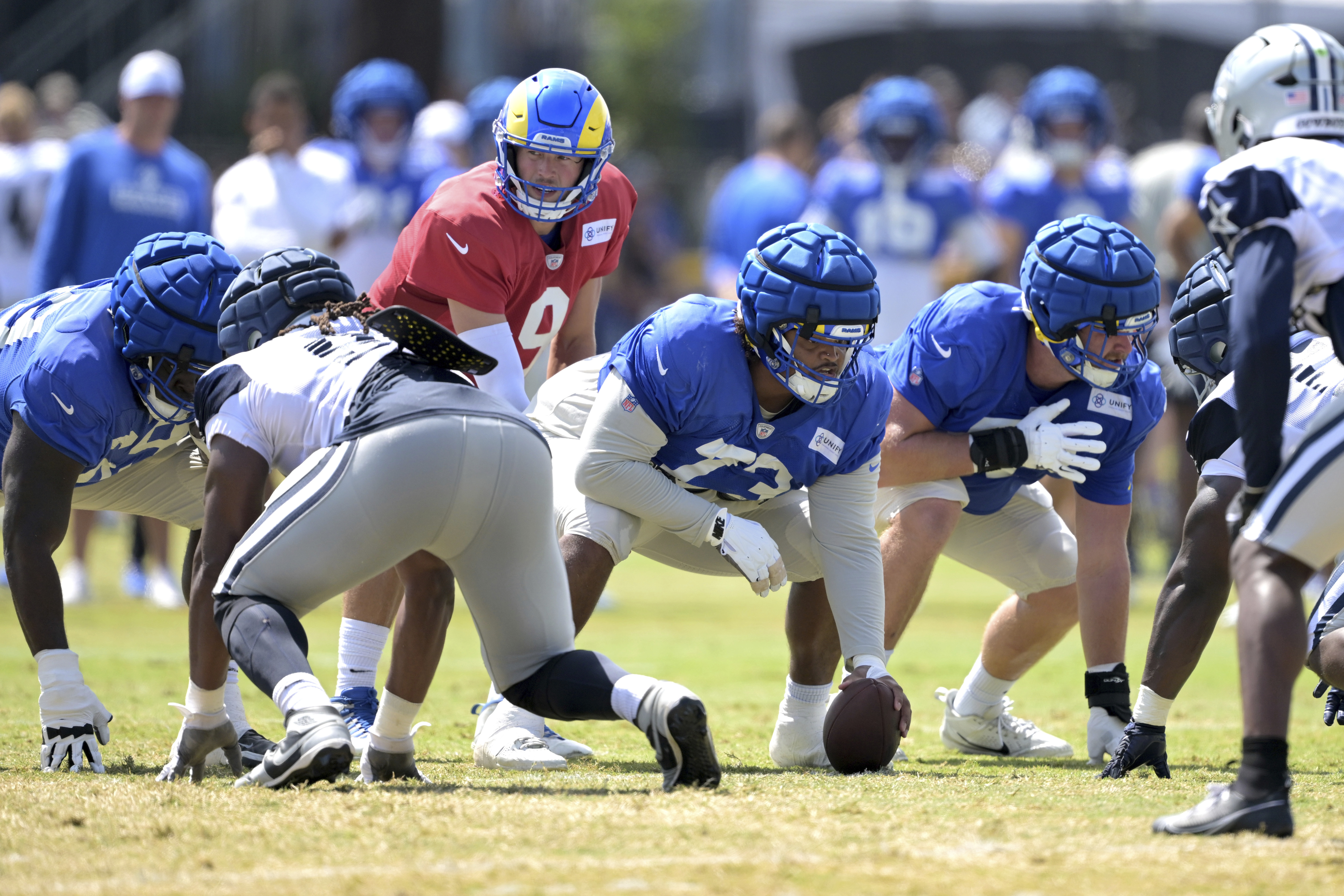 Los Angeles Rams quarterback Matthew Stafford (9) takes the snap from center Steve Avila during a joint practice with the Dallas Cowboys at the Cowboy's NFL football training camp Thursday, Aug. 8, 2024, in Oxnard, Calif. 