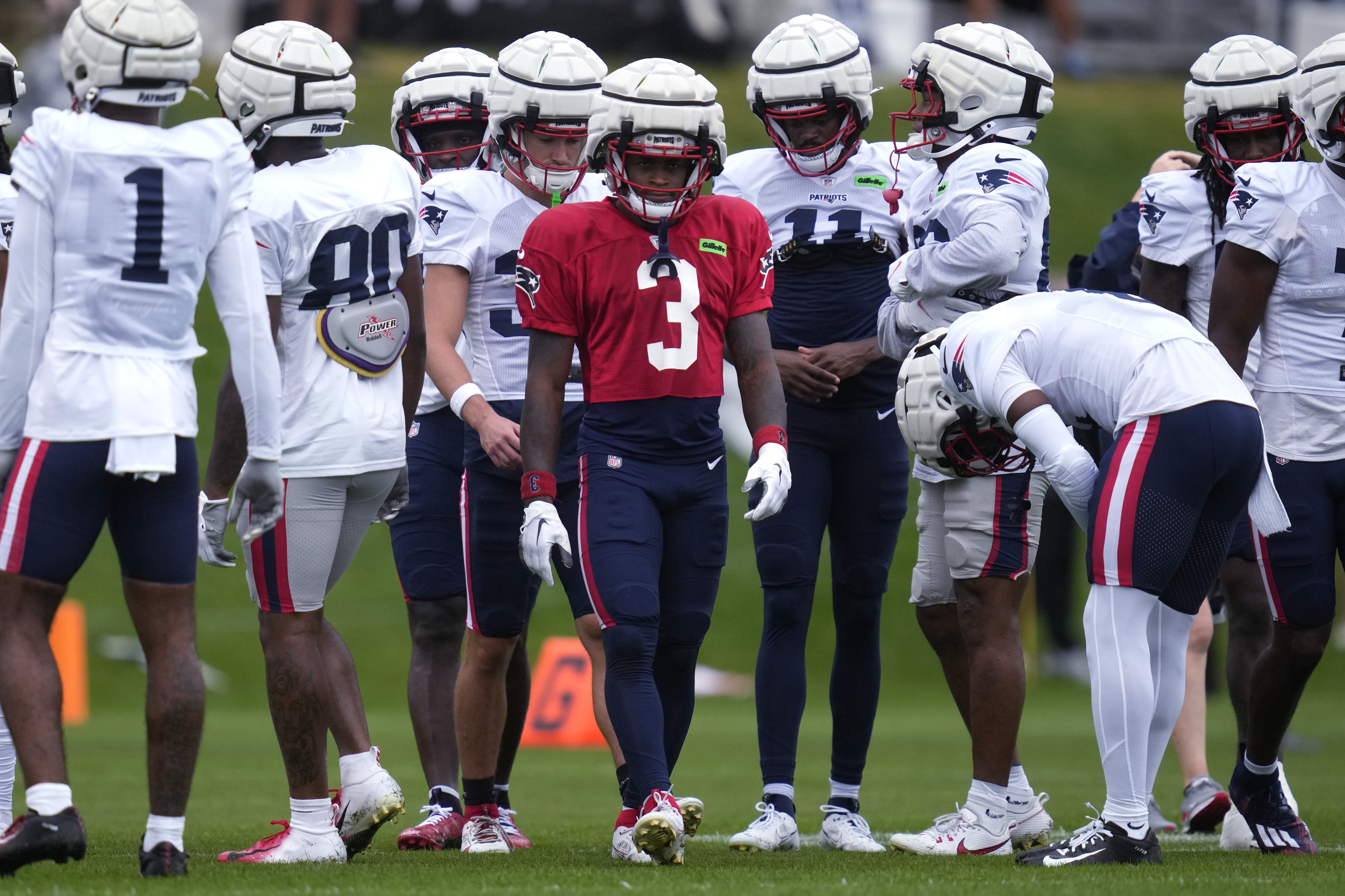 New England Patriots wide receiver DeMario Douglas (3) gathers with teammates during a football practice, Tuesday, Aug. 6, 2024, in Foxborough, Mass.