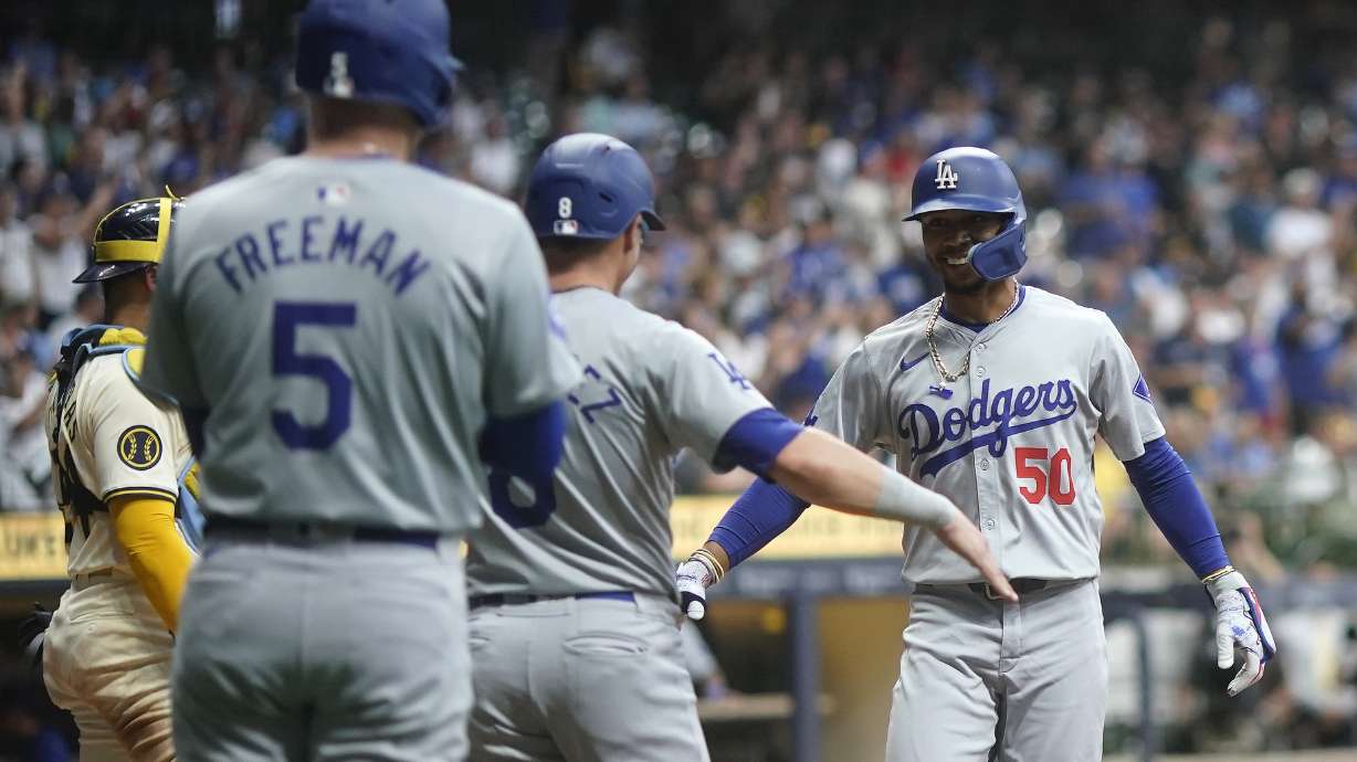 Los Angeles Dodgers' Mookie Betts (50) is congratulated by teammates after hitting a two-run home run during the third inning of a baseball game against the Milwaukee Brewers, Monday, Aug. 12, 2024, in Milwaukee.