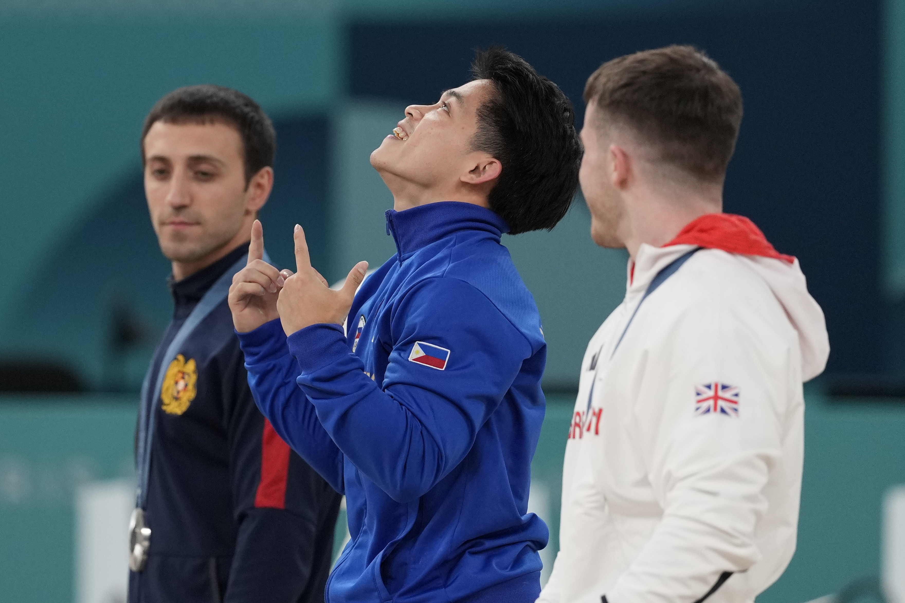 Silver medalist Artur Davtyan, left, of Armenia, stands in the podium with gold medalist Carlos Edriel Yulo, center, of the Philippines, and bronze medalist Harry Hepworth, of Britain, during the medal ceremony for the men's artistic gymnastics individual vault finals at Bercy Arena at the 2024 Summer Olympics, Sunday, Aug. 4, 2024, in Paris, France.