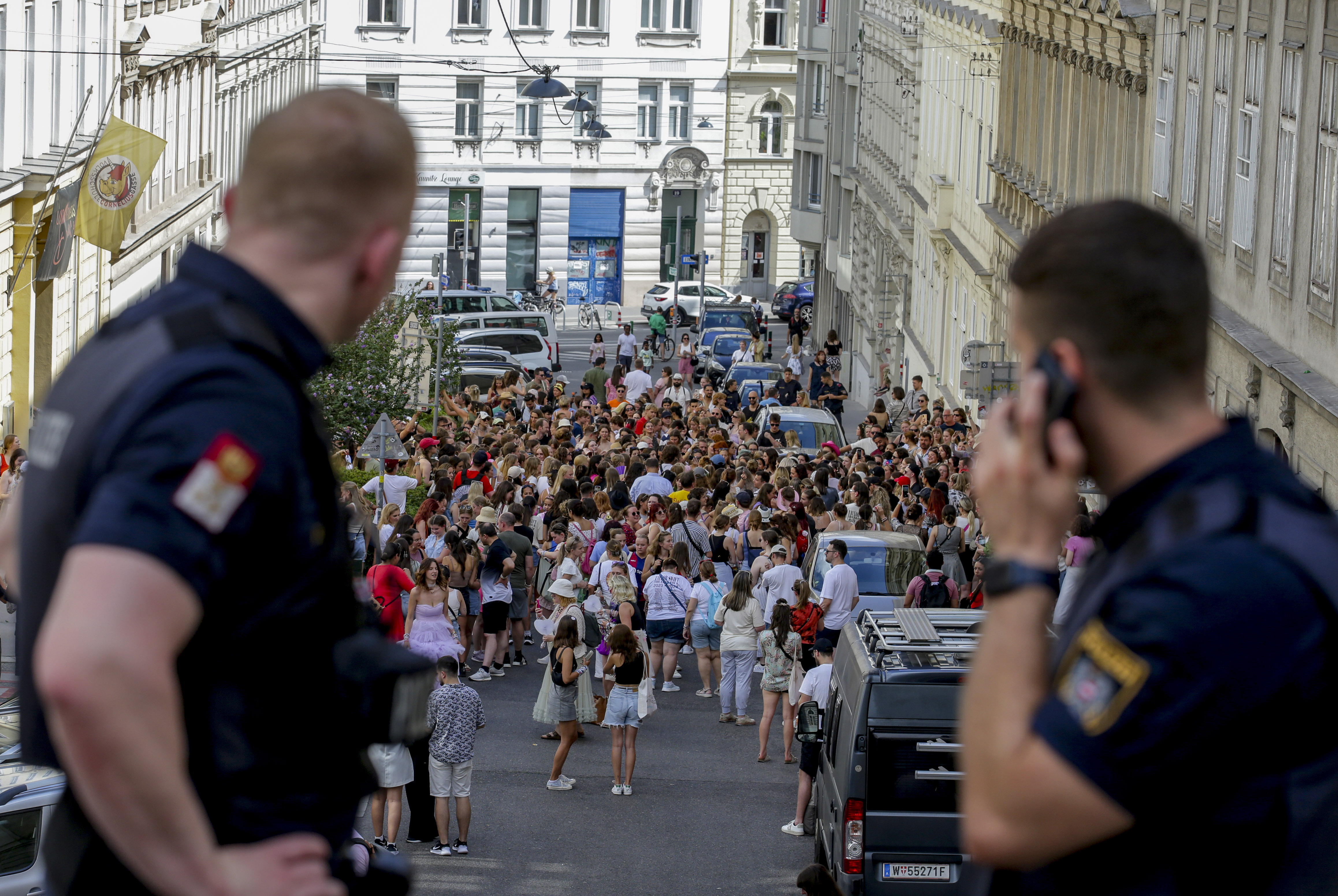 Austrian police officers watch fans of Taylor Swift gather in Vienna on Aug. 8. Concert organizers in Vienna this week called off three events after officials announced arrests over an apparent plot to launch an attack on an event in the Vienna area such as the concerts. 