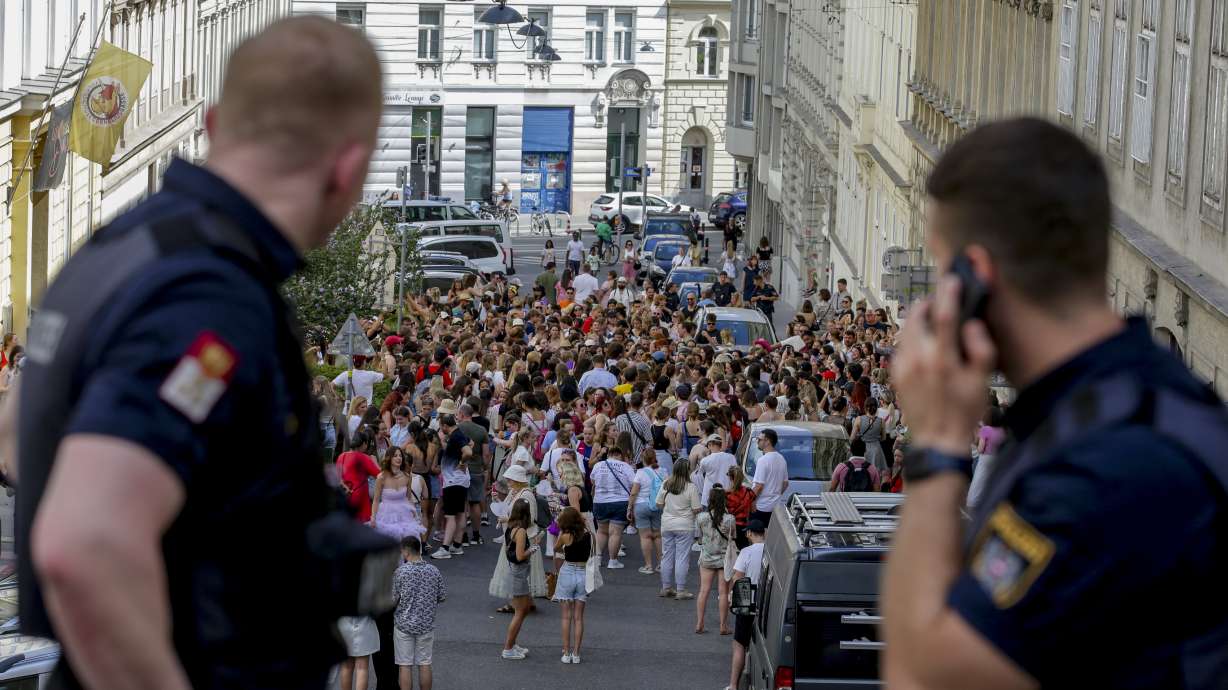 Austrian police officers watch fans of Taylor Swift gather in Vienna on Aug. 8. Concert organizers in Vienna this week called off three events after officials announced arrests over an apparent plot to launch an attack on an event in the Vienna area such as the concerts.