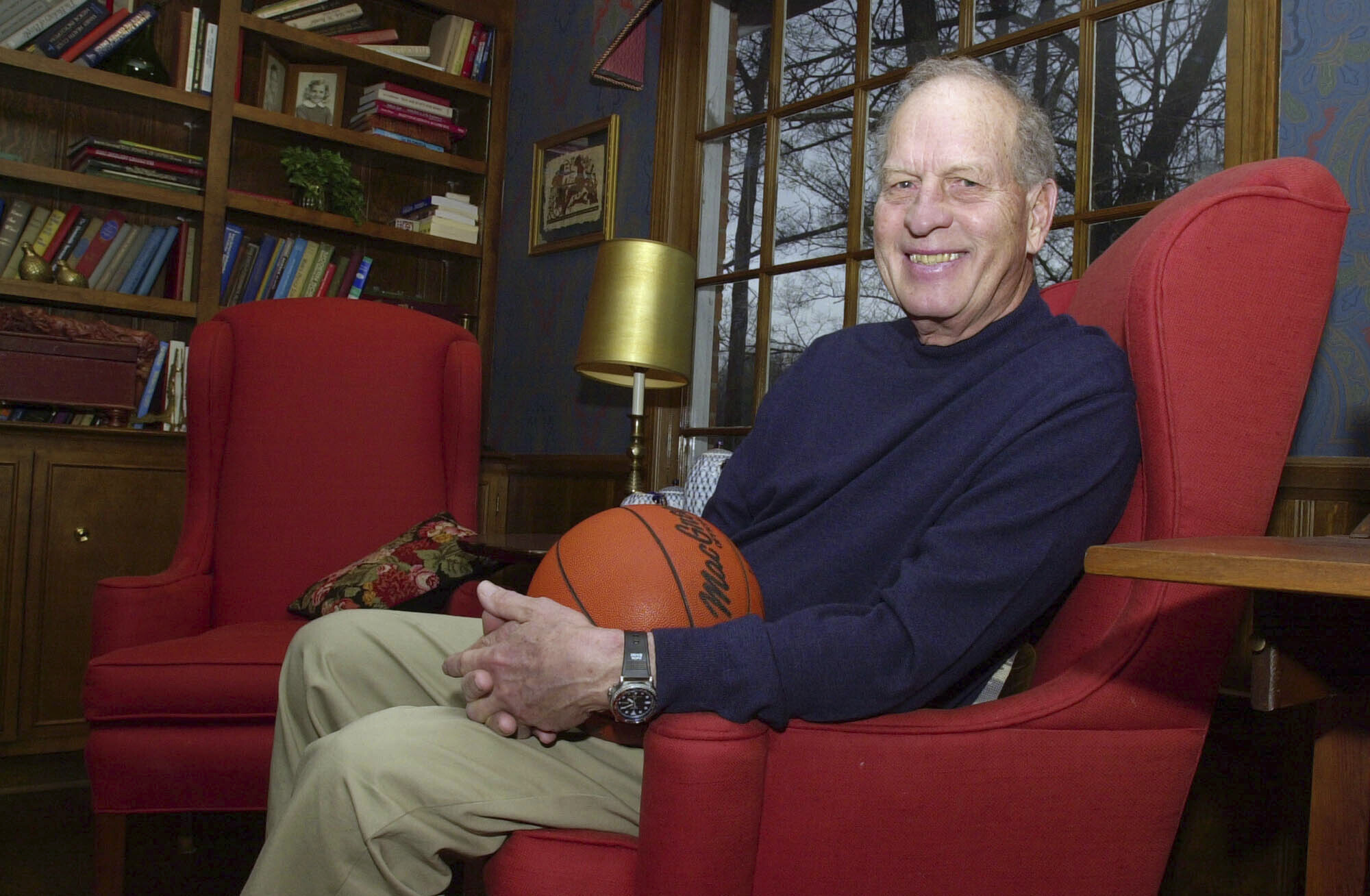 FILE - Frank Selvy poses with a basketball that belongs to his son, Mike, at his home Thursday, Feb. 5, 2004, in Simpsonville, S.C. Selvy, an All-America guard at Furman who scored an NCAA Division I-record 100 points in a game and later played nine NBA seasons, died Tuesday, Aug. 13, 2024. 