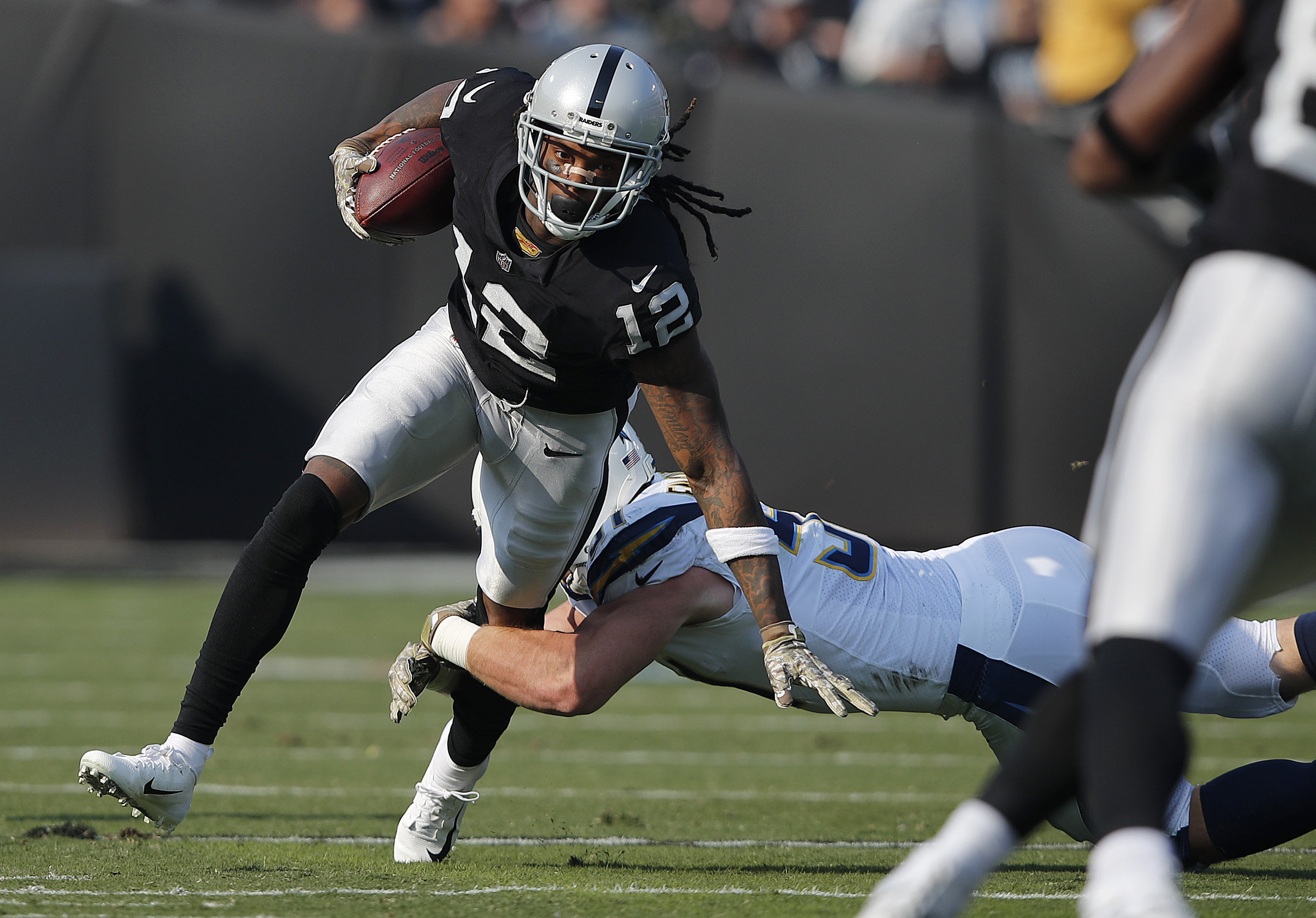 FILE - Oakland Raiders wide receiver Martavis Bryant (12) runs against Los Angeles Chargers linebacker Kyle Emanuel during the first half of an NFL football game in Oakland, Calif., Nov. 11, 2018.