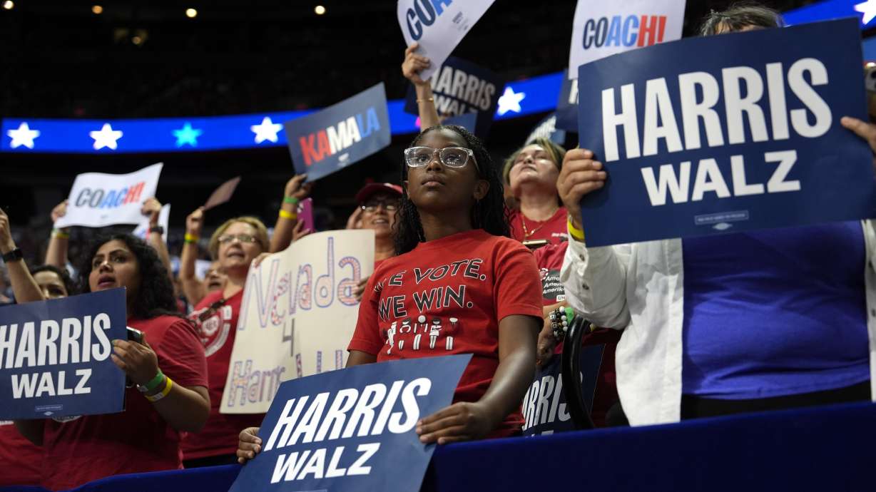 Supporters carry signs as Democratic presidential nominee Vice President Kamala Harris speaks at a campaign rally, Aug. 10 in Las Vegas, Nev. How to add a possessive to the candidate's name is an ongoing question.