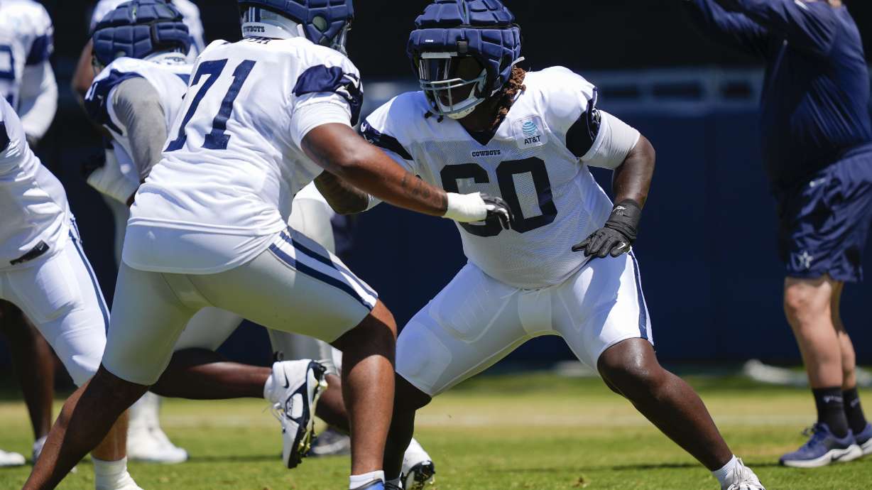 Dallas Cowboys offensive tackle Tyler Guyton, right, and guard Chuma Edoga run drills during NFL football training camp, Tuesday, July 30, 2024, in Oxnard, Calif.