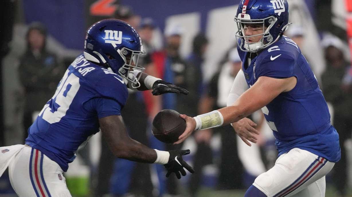 New York Giants quarterback Drew Lock (2) hands off the ball to New York Giants running back Tyrone Tracy Jr. (29) during the first quarter of an NFL football game, Thursday, Aug. 8, 2024, in East Rutherford, N.J.