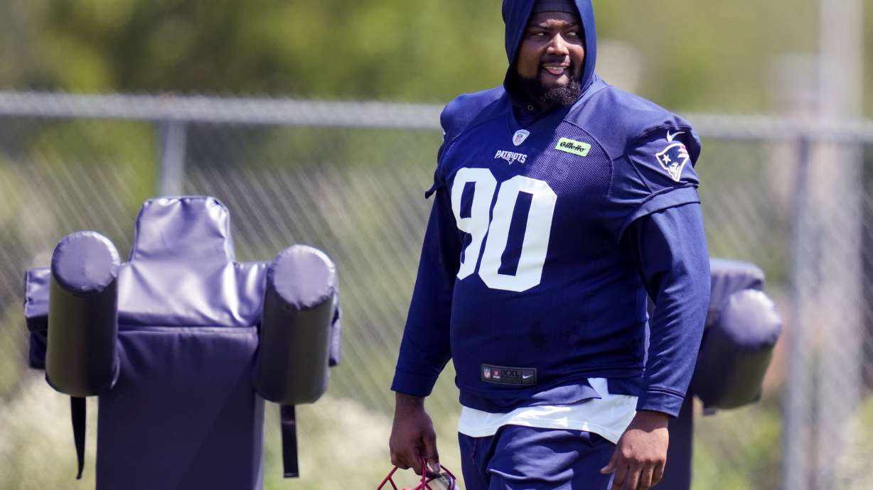New England Patriots defensive tackle Christian Barmore (90) watches his teammates practice during an NFL football training camp, Friday, July 26, 2024, in Foxborough, Mass.