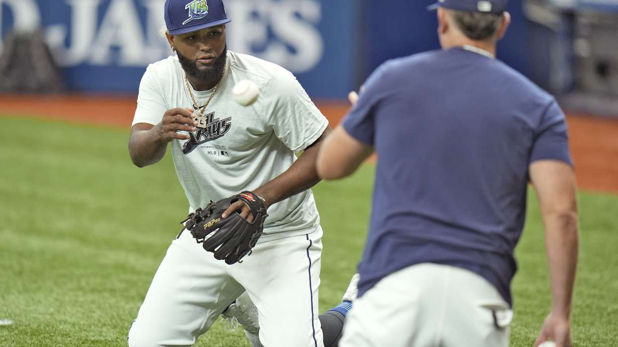 Newly called up Tampa Bay Rays third baseman Junior Caminero, left, works on drills with Brady Williams before a baseball game against the Houston Astros Tuesday, Aug. 13, 2024, in St. Petersburg, Fla.