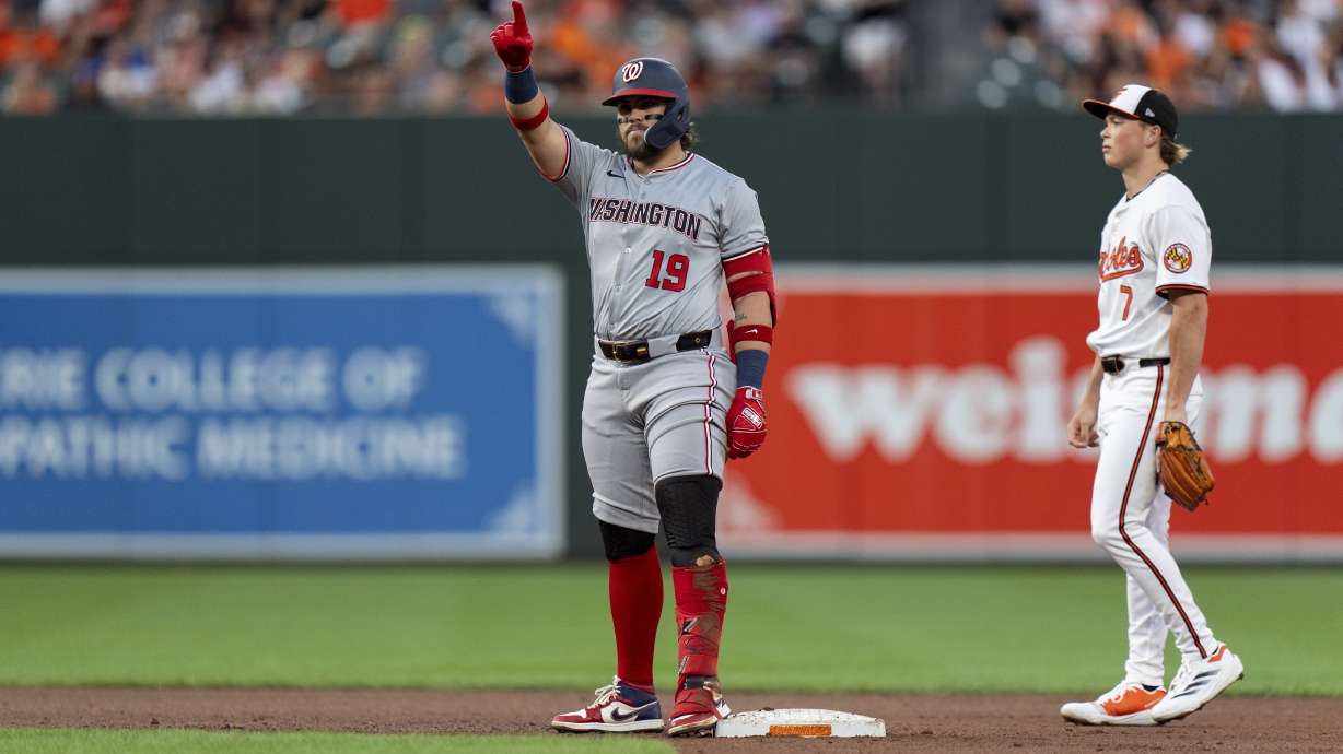 Washington Nationals' Andres Chaparro (19) celebrates on second base in front of Baltimore Orioles second baseman Jackson Holliday (7) after hitting a double during the fourth inning of a baseball game, Tuesday, Aug. 13, 2024, in Baltimore.