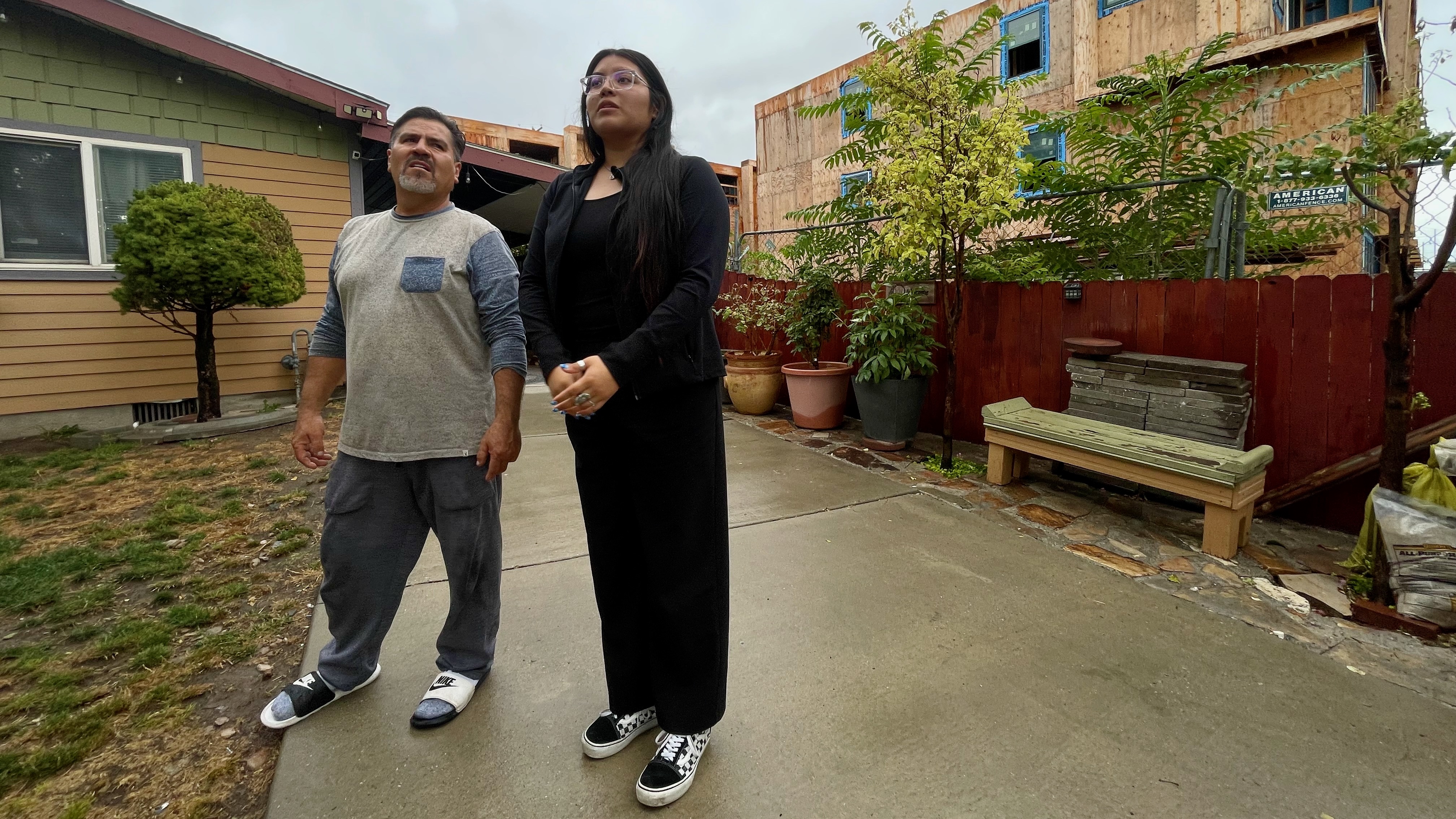 Jose Luis Leal and his daughter Alexandra Leal Vergara outside their home on Salt Lake City's west side Monday, with a partially built townhome complex behind them.