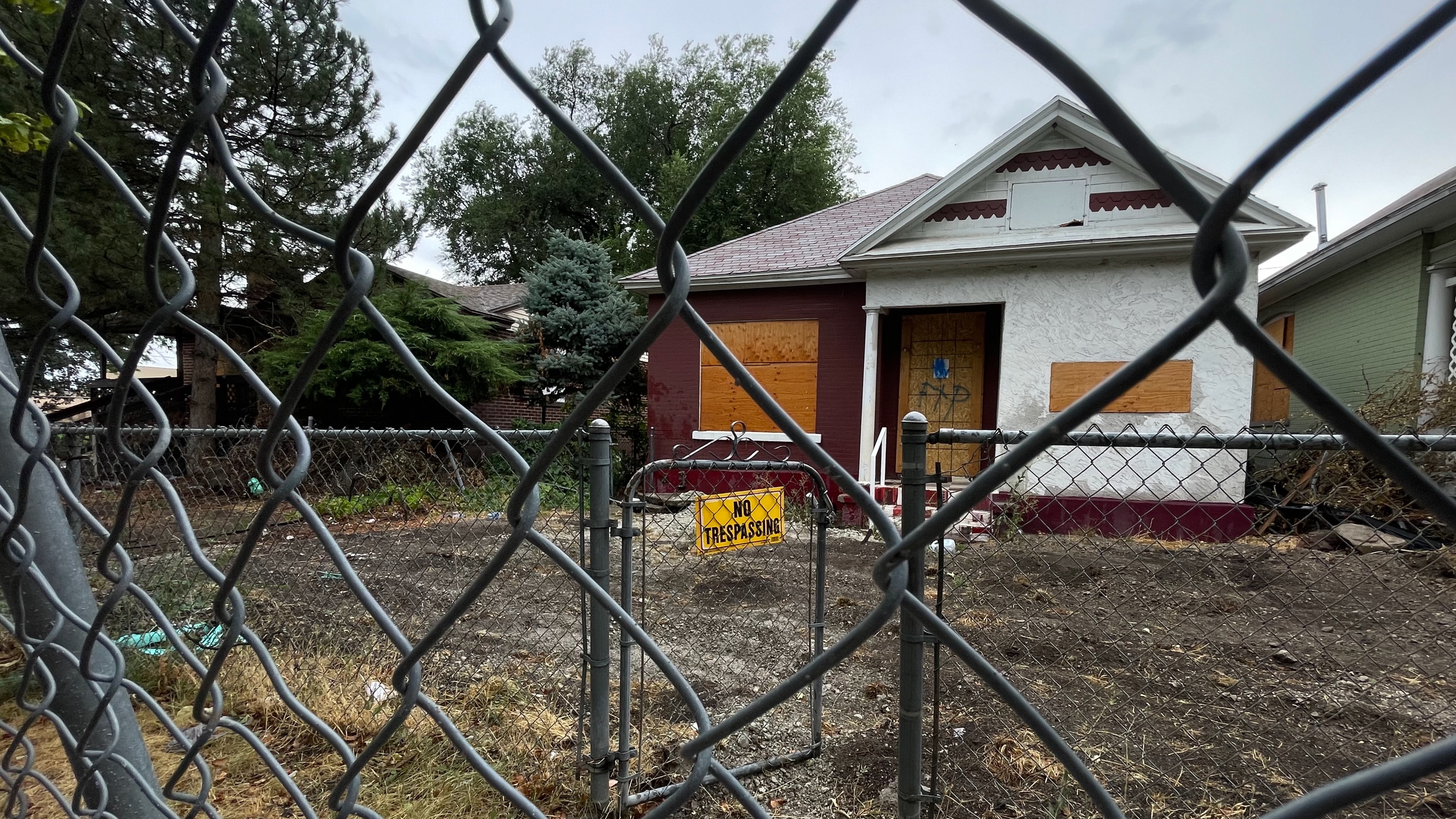 A vacant and boarded up house on Salt Lake City's west side across the street from the home of Jose Luis Leal on Monday.