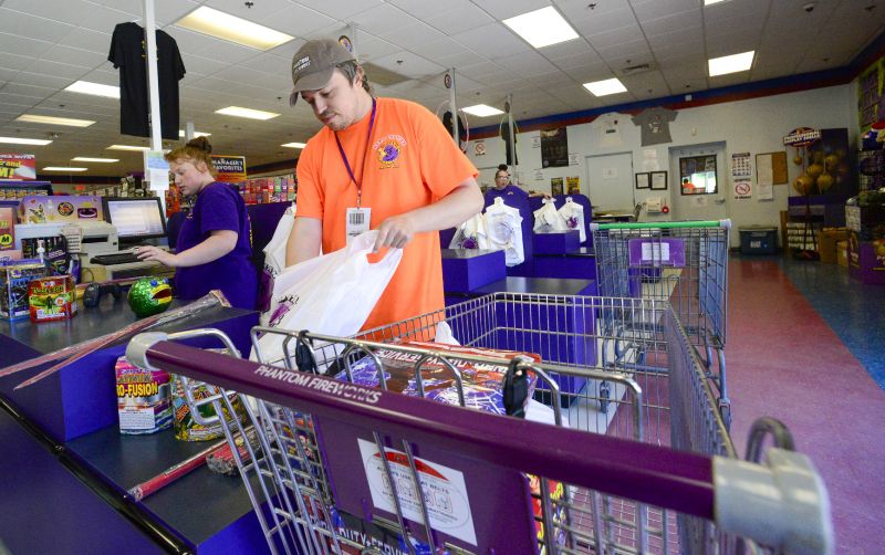 James Pratt, head cashier at Phantom Fireworks in Hinsdale, N.H., helps bag a customer's order on June 28.