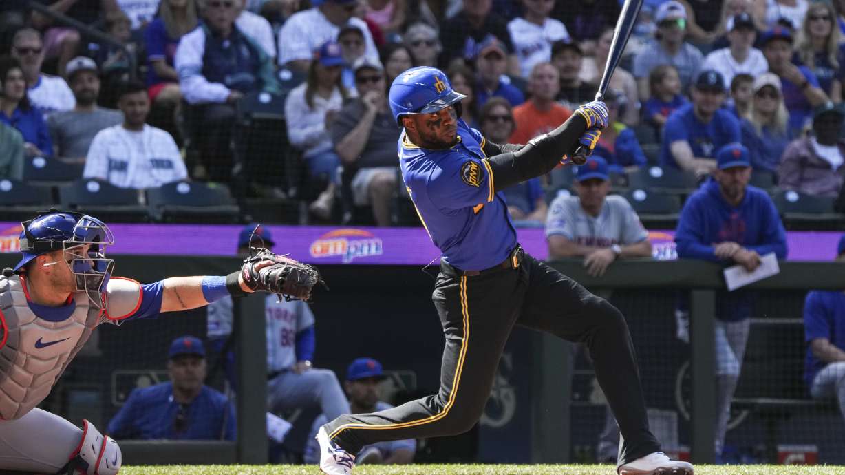 Seattle Mariners' Victor Robles, right, hits the ball for a foul during the first inning of a game against the New York Mets, Sunday, Aug. 11, 2024, in Seattle.