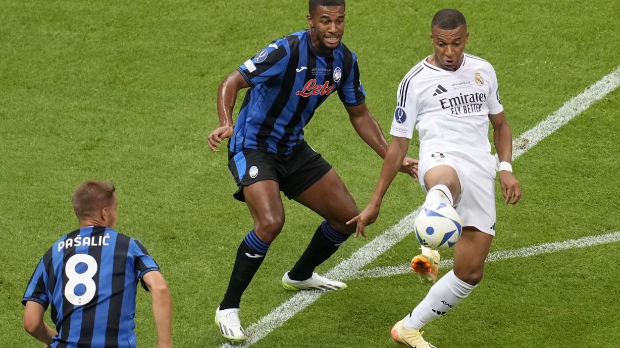 Real Madrid's Kylian Mbappe, right, controls the ball next to Atalanta's Isak Hien during the UEFA Super Cup Final soccer match between Real Madrid and Atalanta at the Narodowy stadium in Warsaw, Poland, Wednesday, Aug. 14, 2024.