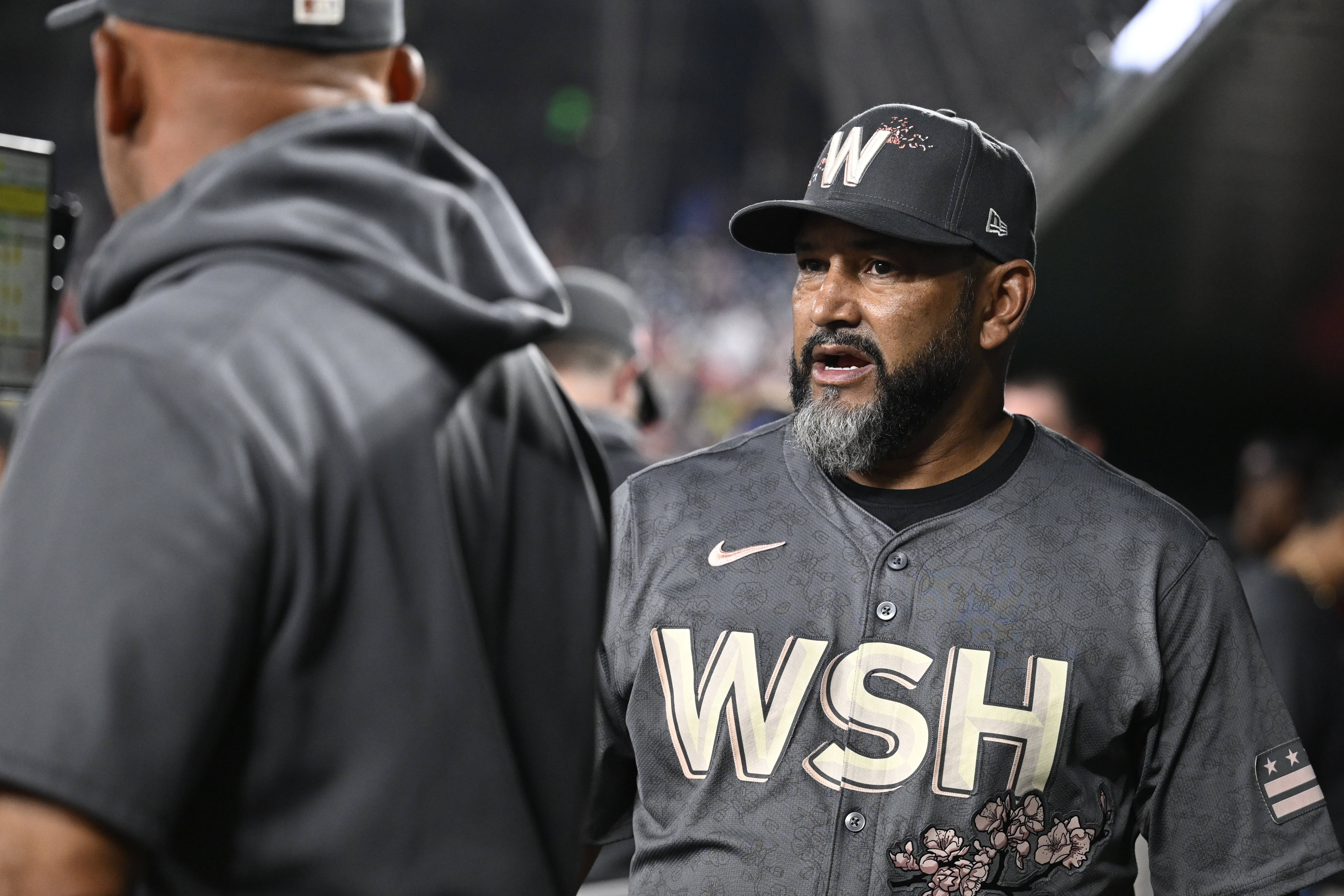 Washington Nationals manager Dave Martinez, right, talks with his coaches in the dugout during the eighth inning of a baseball game against the Los Angeles Angels, Saturday, Aug. 10, 2024, in Washington.