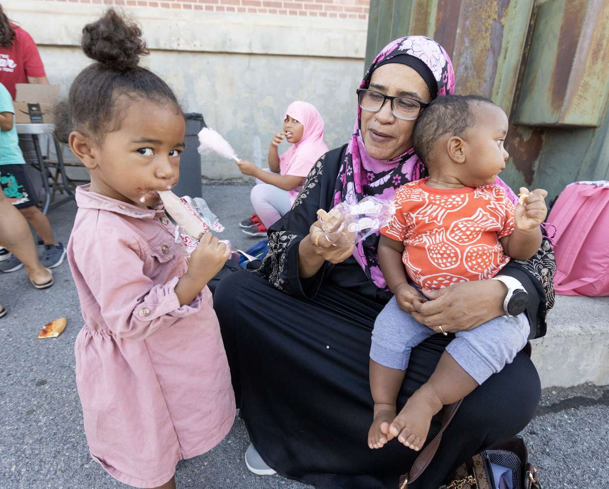 Mkuu Vae, center, eats ice cream with her grandchildren, Yassin Vae, 1, on the right and Hannan Yasmin, 3, on the left, during Utah Refugee Connection’s annual back-to-school event at Granite Park Junior High School in South Salt Lake on Aug. 6.