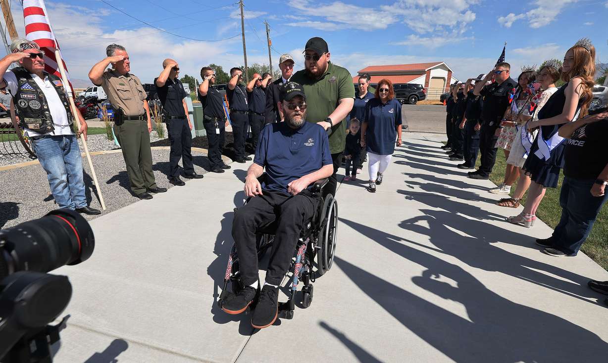 United States Air Force Technical Sgt. Jesse Clark is wheeled through a procession as he sees his new, mortgage-free smart home from Tunnel to Towers Foundation in Tooele on Wednesday. Clark was diagnosed with a brain tumor linked to chemical exposure during the Gulf War.