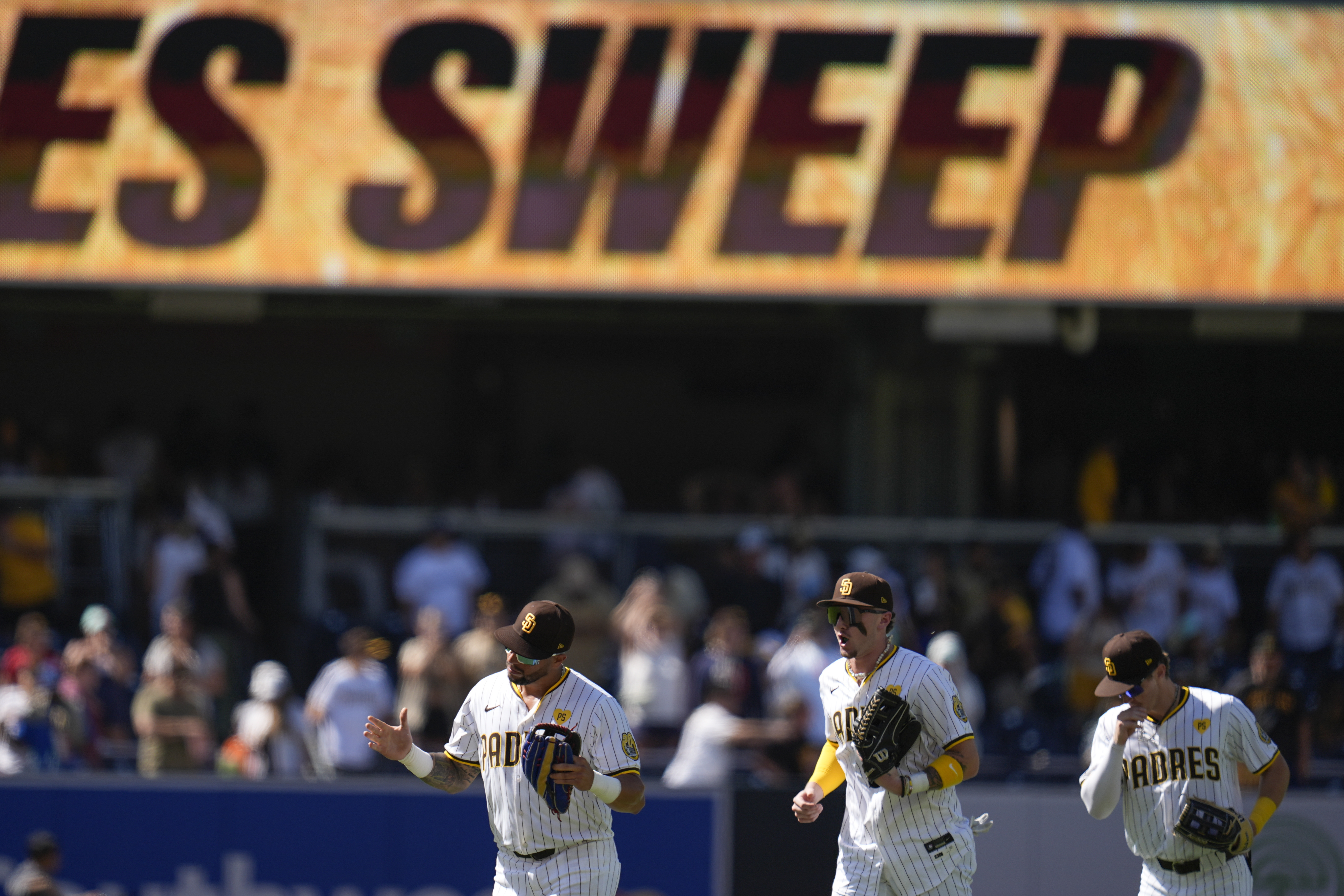 San Diego Padres right fielder David Peralta, left, celebrates with teammates center fielder Jackson Merrill and left fielder Bryce Johnson after the Padres defeated the Pittsburgh Pirates 8-2 in a baseball game to sweep the series, Wednesday, Aug. 14, 2024, in San Diego. 