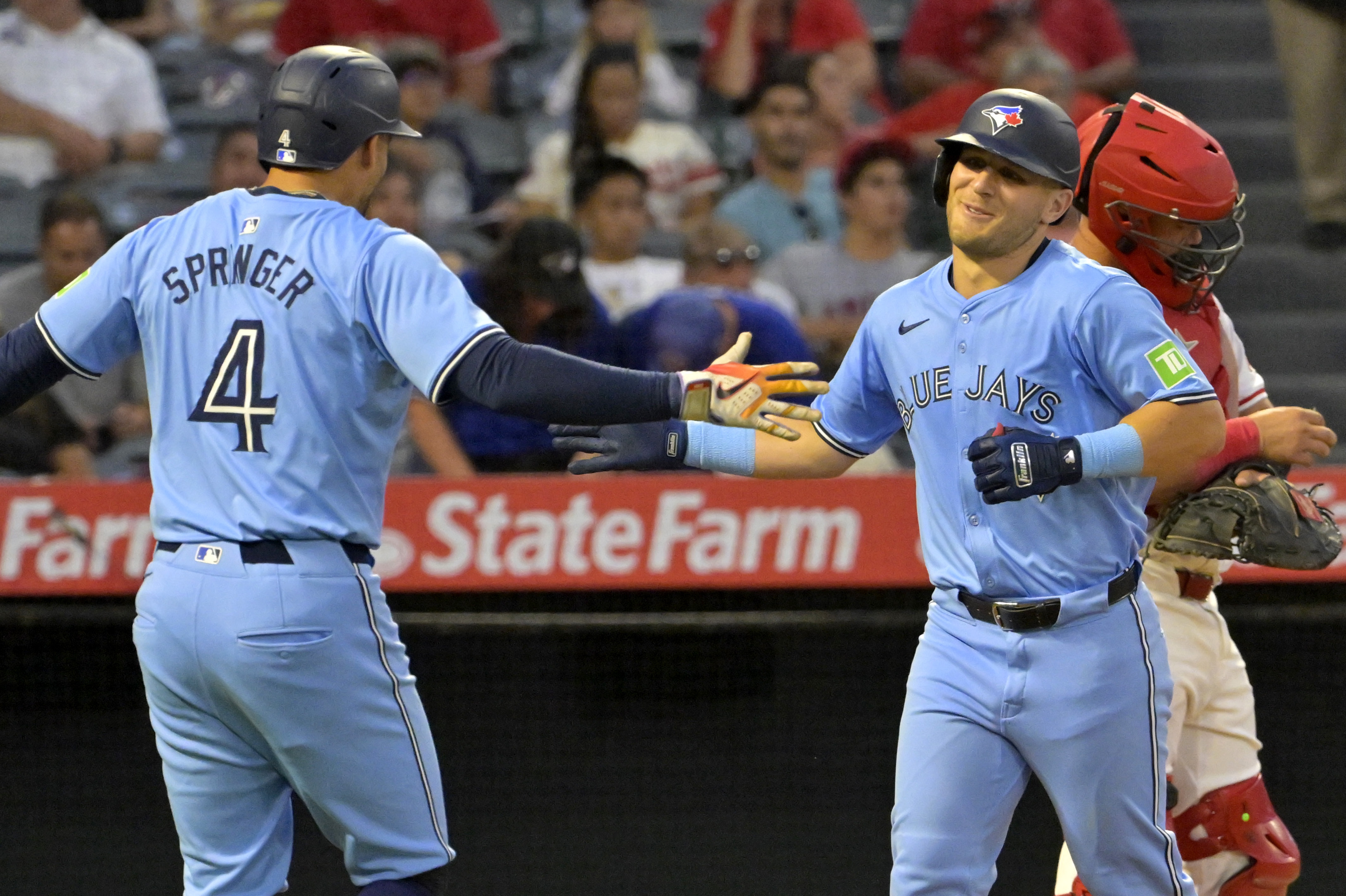 Toronto Blue Jays' Daulton Varsho is congratulated by George Springer (4) after hitting a three-run home run in the fifth inning of a baseball game against the Los Angeles Angels Wednesday, Aug. 14, 2024, in Anaheim, Calif.