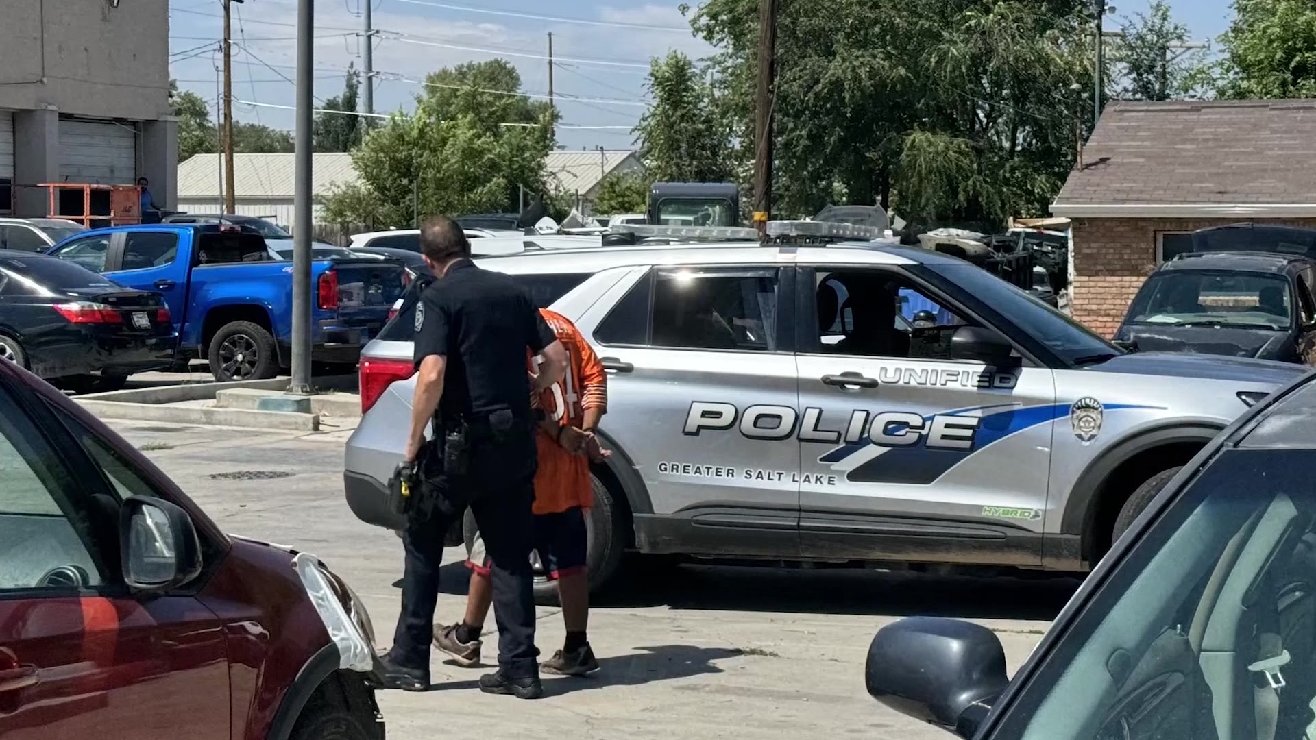 Kevin Allen Russell is seen being escorted by a Unified police officer on Sunday in Millcreek.