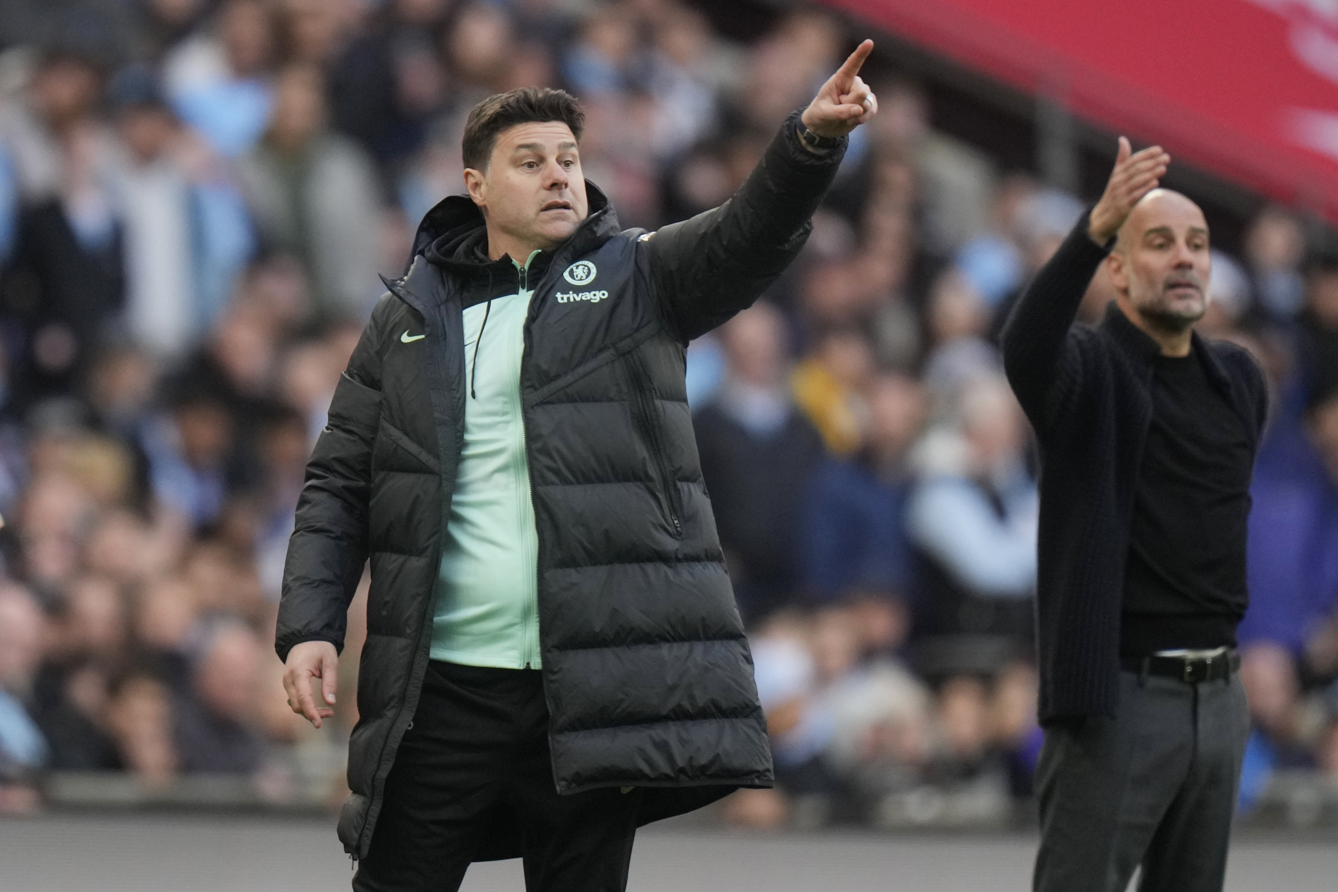 FILE - Chelsea's head coach Mauricio Pochettino, left, and Manchester City's head coach Pep Guardiola gesture during the English FA Cup semifinal soccer match between Manchester City and Chelsea at Wembley stadium in London, Saturday, April 20, 2024. 