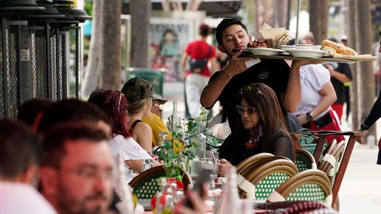 A waiter delivers food to patrons at a restaurant, Jan. 21, 2022, in Miami Beach, Fla. Vice President Kamala Harris and former President Donald Trump found common ground recently when they both supported slashing taxes on tips.