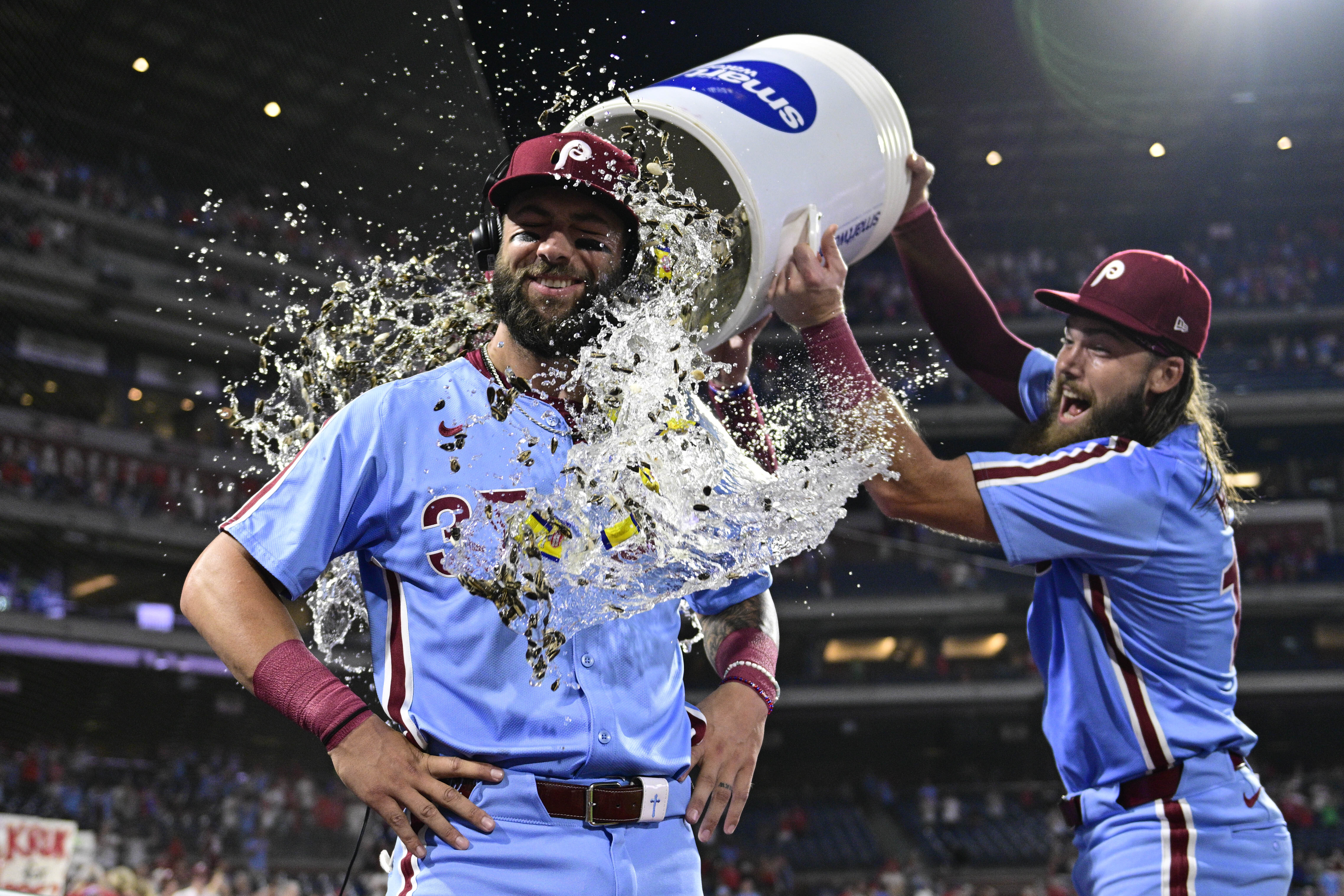 Philadelphia Phillies' Weston Wilson, center, is doused by teammates Brandon Marsh, right, and Bryson Stott after a victory over the Washington Nationals in a baseball game, Thursday, Aug. 15, 2024, in Philadelphia. 