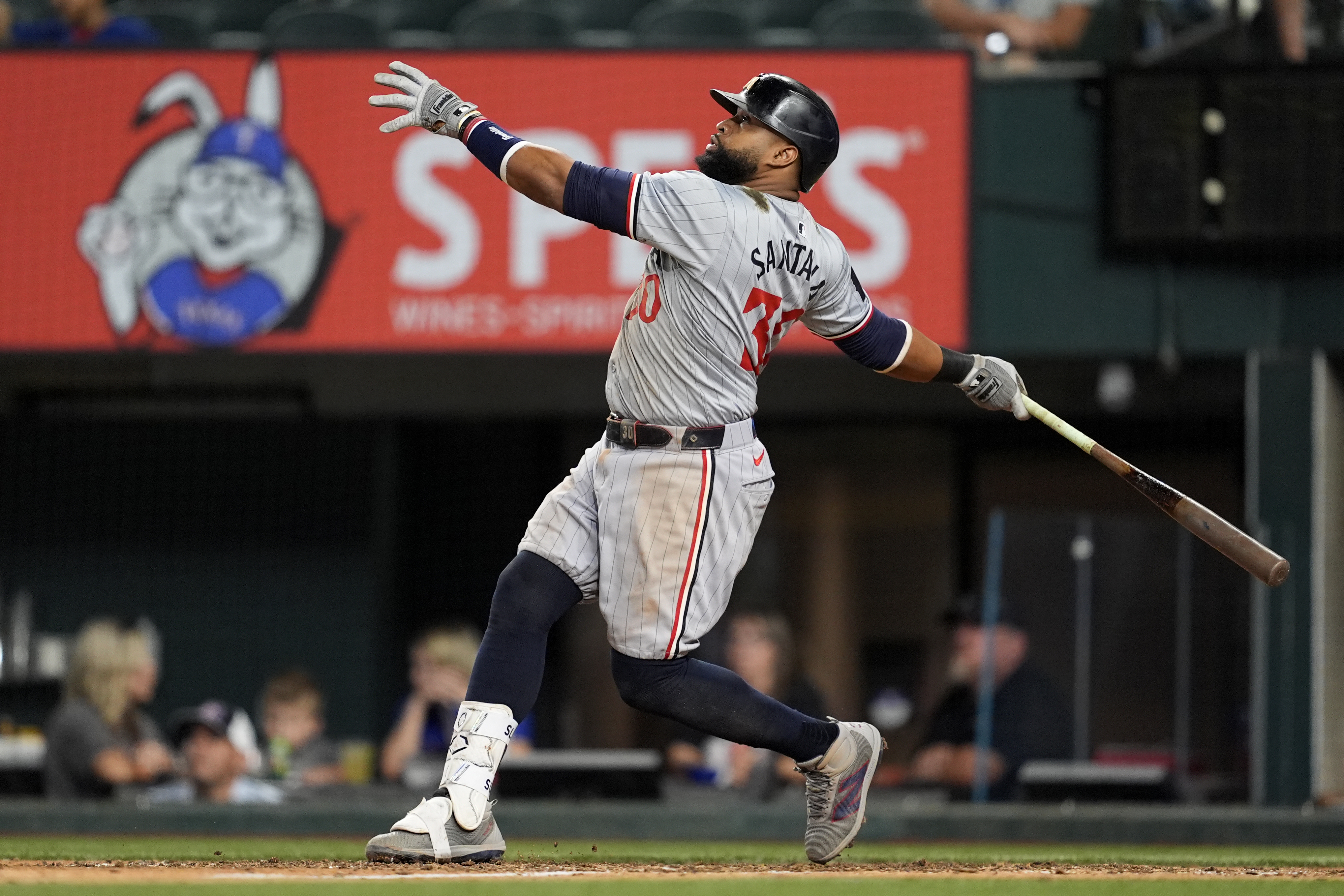 Minnesota Twins' Carlos Santana follows through on a sacrifice fly that scored Matt Wallner in the ninth inning of a baseball game against the Texas Rangers, Thursday, Aug. 15, 2024, in Arlington, Texas. 
