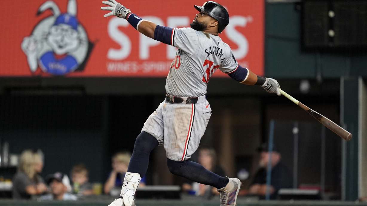 Minnesota Twins' Carlos Santana follows through on a sacrifice fly that scored Matt Wallner in the ninth inning of a baseball game against the Texas Rangers, Thursday, Aug. 15, 2024, in Arlington, Texas.