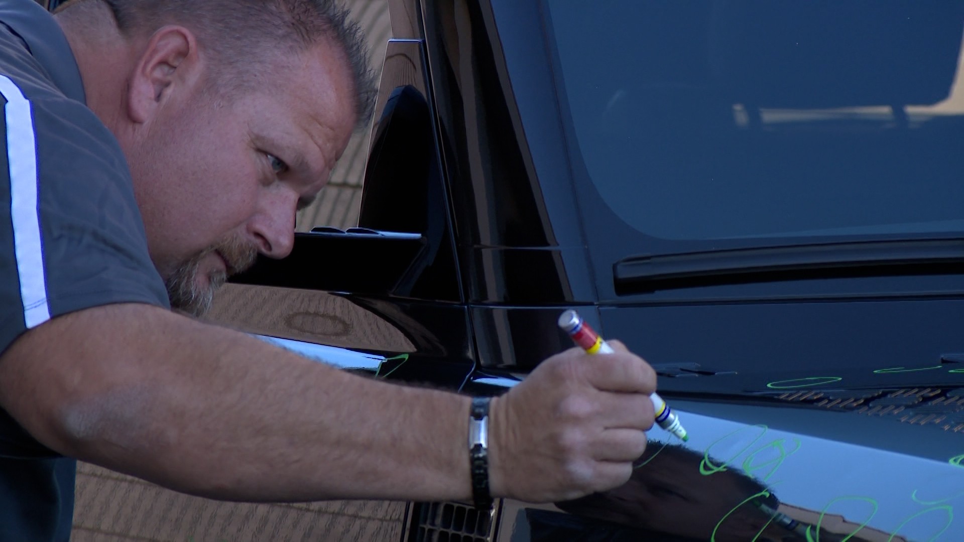 Travis Olsen marks hail damage on a customer’s car Thursday in American Fork. Body shops are busy after Tuesday's storm.