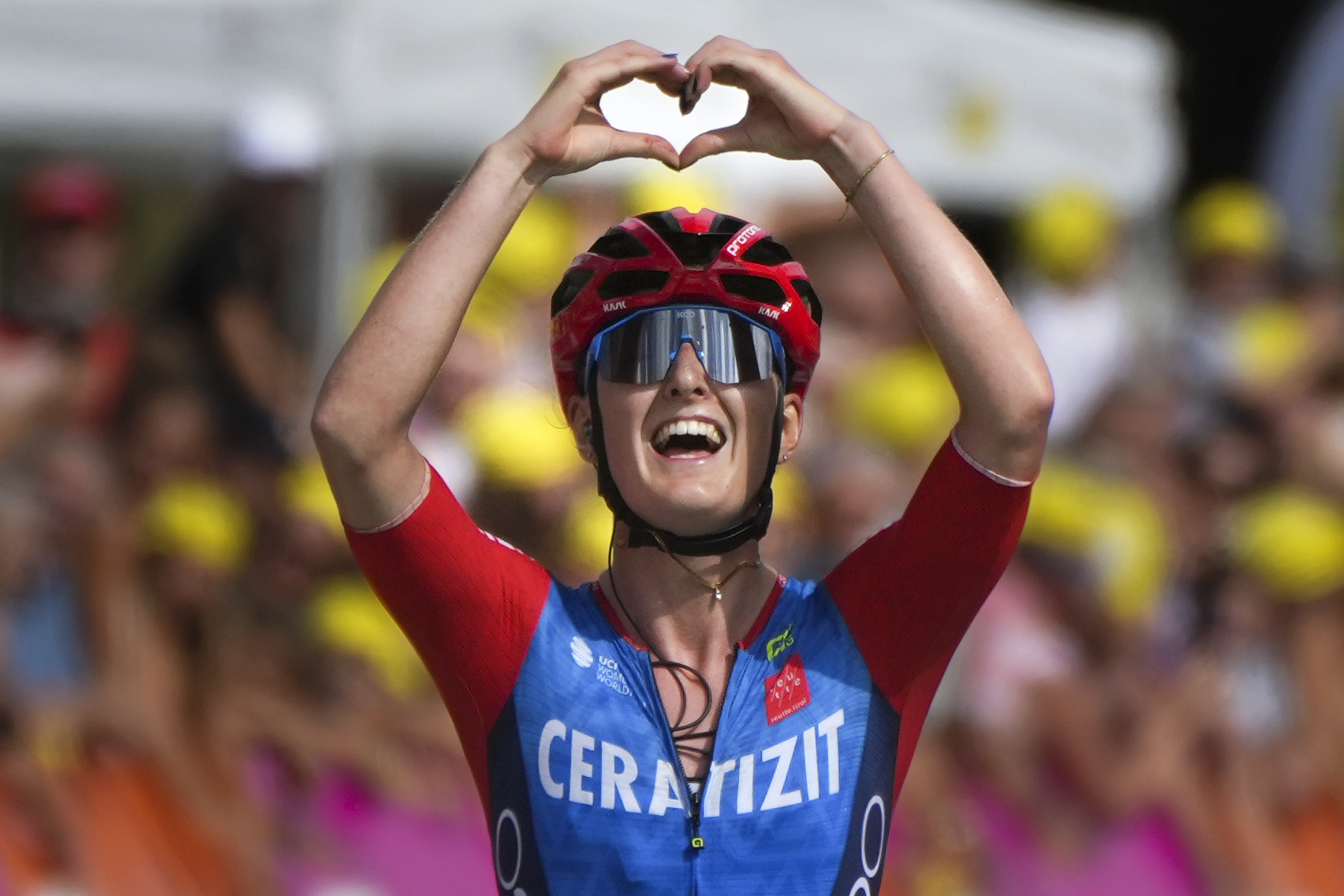 Cedrine Kerboal of France forms a heart as she crosses the finish line to win the sixth stage of the Tour de France Women cycling race with start in Remiremont and finish in Morteau, France, Friday, Aug. 16, 2024. 