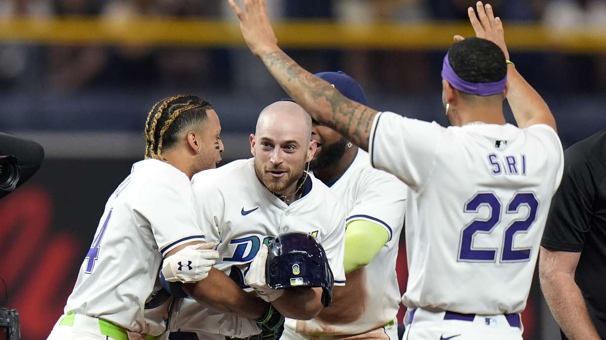 Tampa Bay Rays' Brandon Lowe, center, celebrates his walkoff single off Arizona Diamondbacks relief pitcher Justin Martinez with Christopher Morel, left, and Jose Siri, right, during the ninth inning of a baseball game Friday, Aug. 16, 2024, in St. Petersburg, Fla.