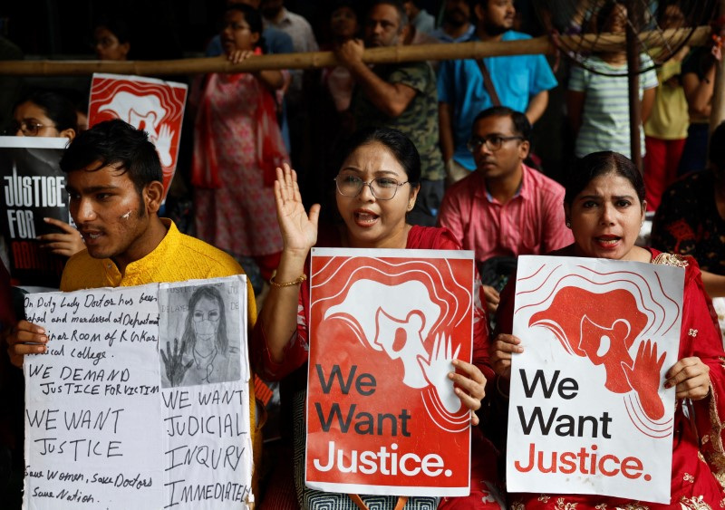 Doctors hold signs as they attend a protest condemning the rape and murder of a trainee doctor, inside the premises of R. G. Kar Medical College and Hospital in Kolkata, India, Friday.