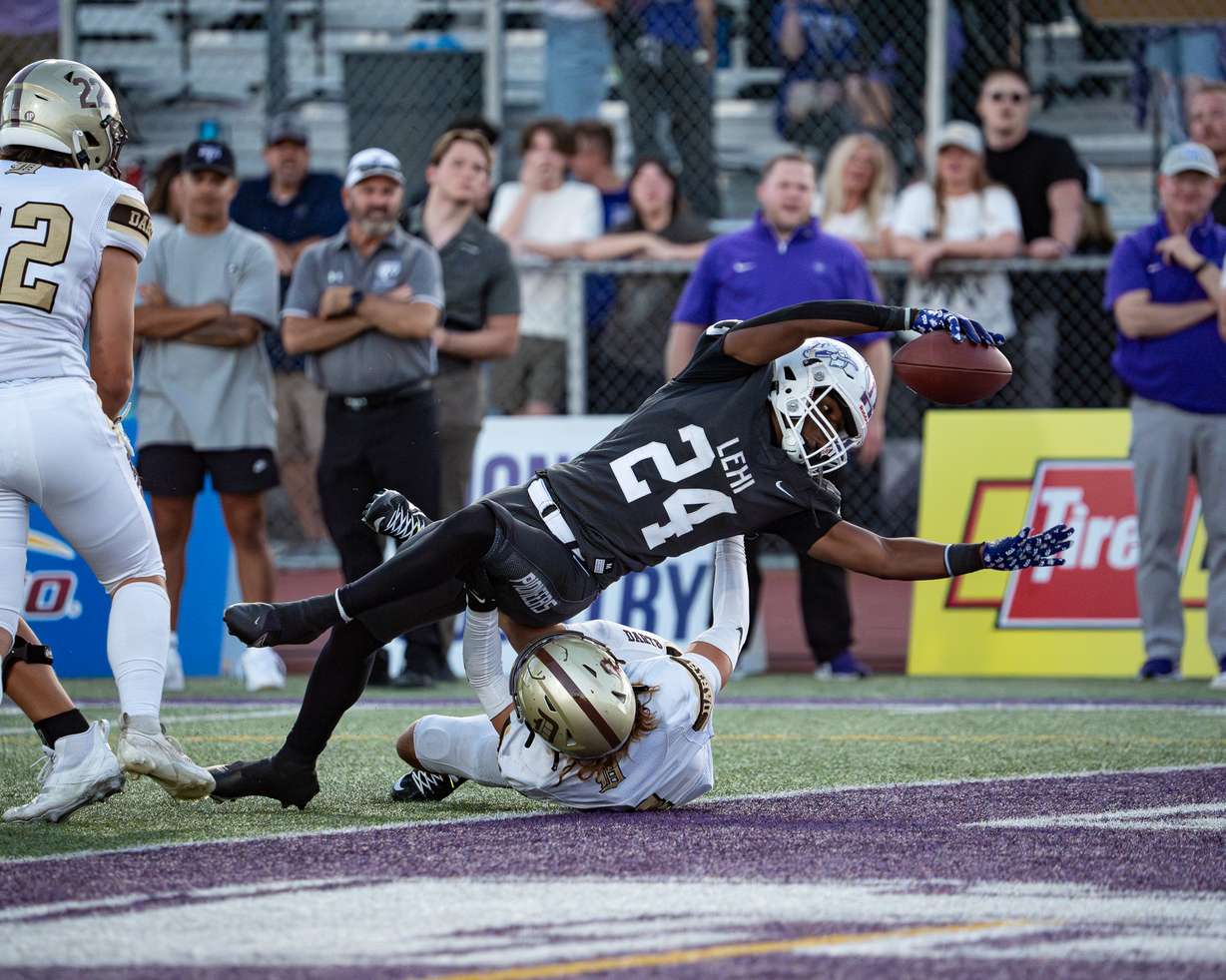 Lehi running back Devaughn Eka reaches for a touchdown over a Davis defender on Aug. 16, 2024 in Lehi.