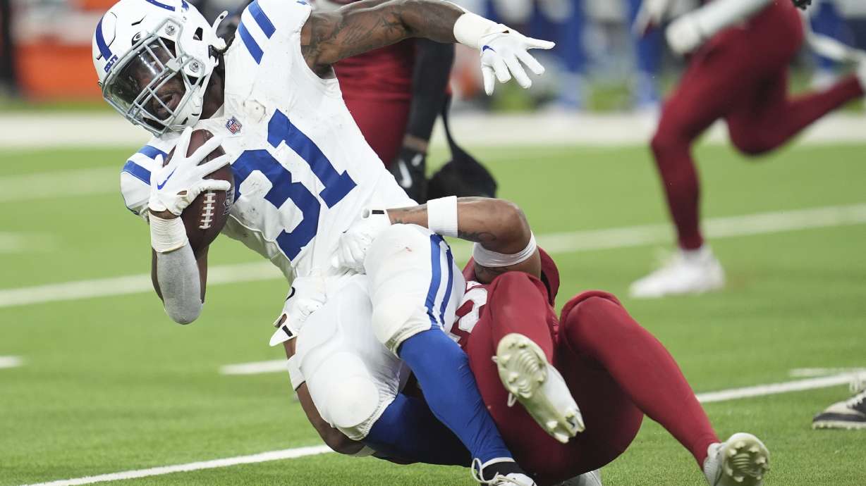 Indianapolis Colts running back Tyler Goodson (31) gets pulled down by Arizona Cardinals safety Dadrion Taylor-Demerson during the first half of a preseason NFL football game, Saturday, Aug. 17, 2024, in Indianapolis.