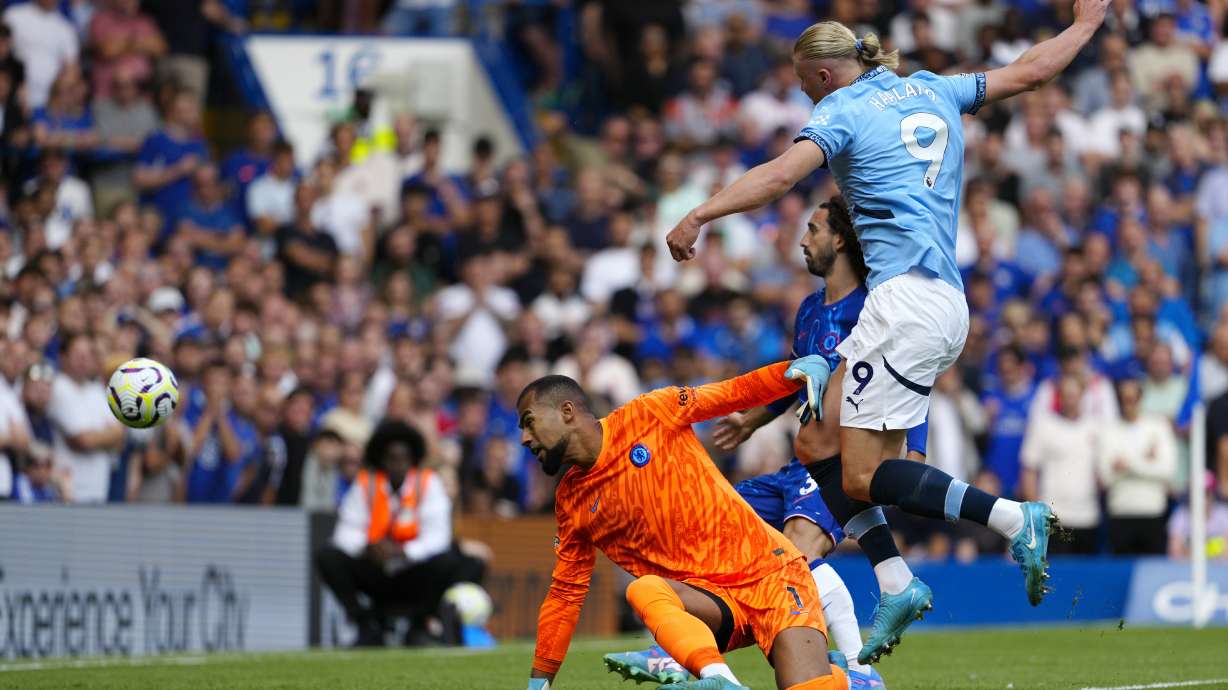 Manchester City's Erling Haaland scores his side's opening goal during the English Premier League soccer match between Chelsea and Manchester City at Stamford Bridge stadium in London, England, Sunday, Aug, 18, 2024.