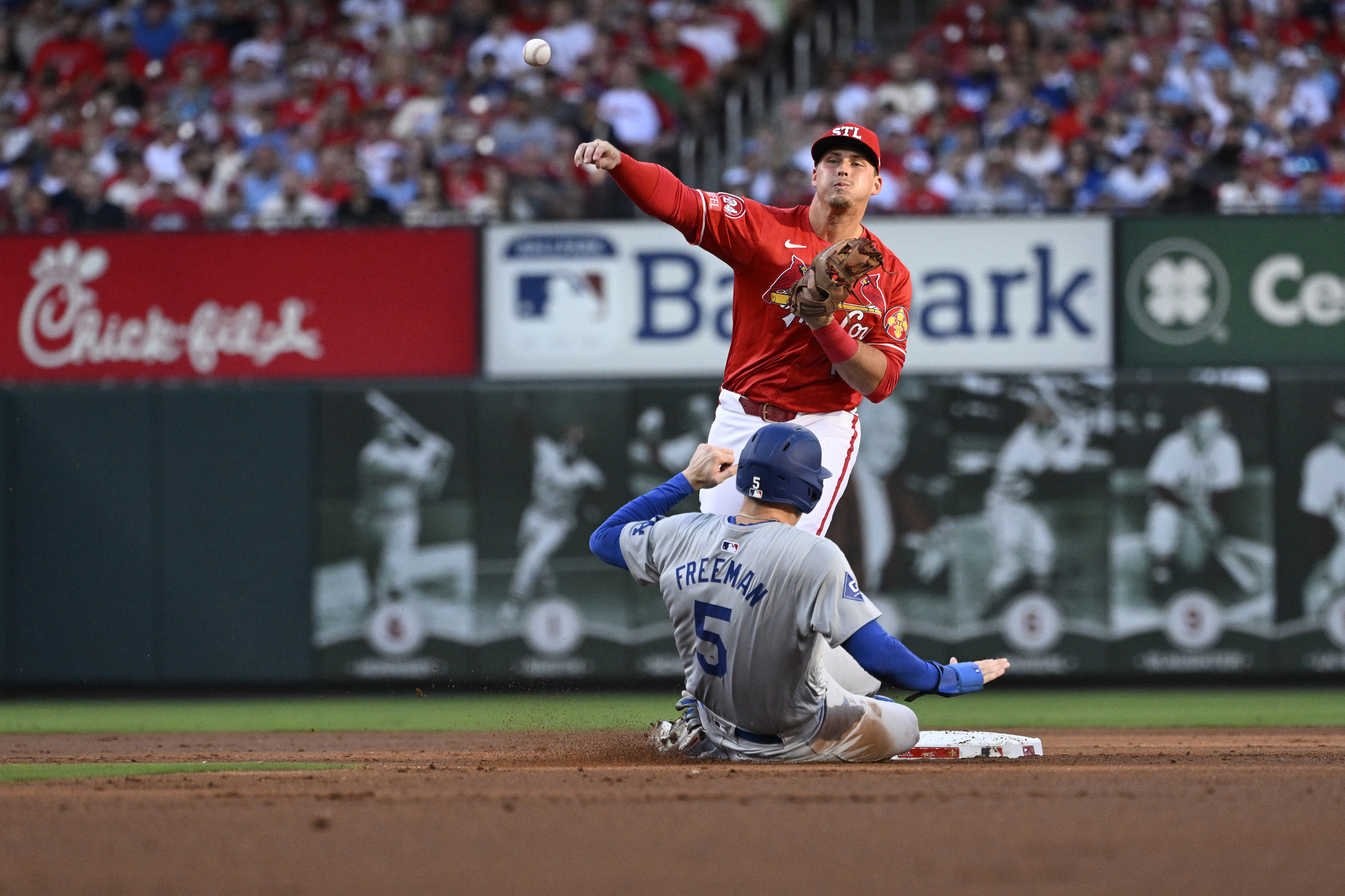 Los Angeles Dodgers' Freddie Freeman (5) is out at second as St. Louis Cardinals second baseman Nolan Gorman, top, throws to first on a double play-attempt against Will Smith during the firsts inning of a baseball game Saturday, Aug. 17, 2024, in St. Louis. 