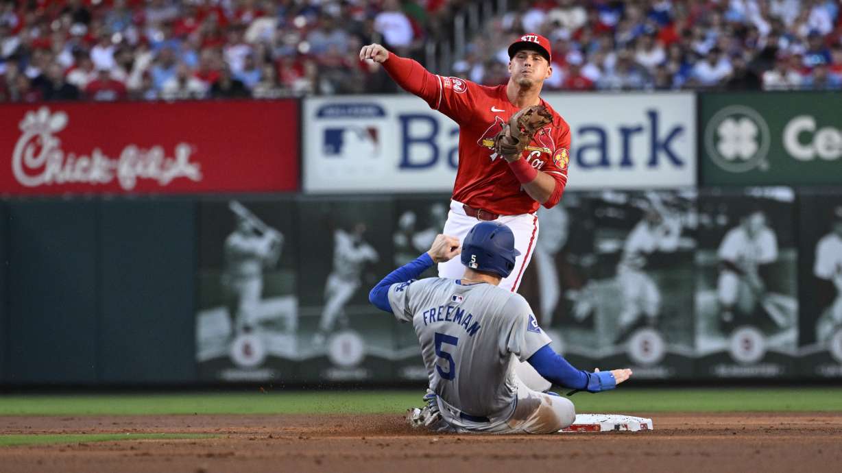Los Angeles Dodgers' Freddie Freeman (5) is out at second as St. Louis Cardinals second baseman Nolan Gorman, top, throws to first on a double play-attempt against Will Smith during the firsts inning of a baseball game Saturday, Aug. 17, 2024, in St. Louis.