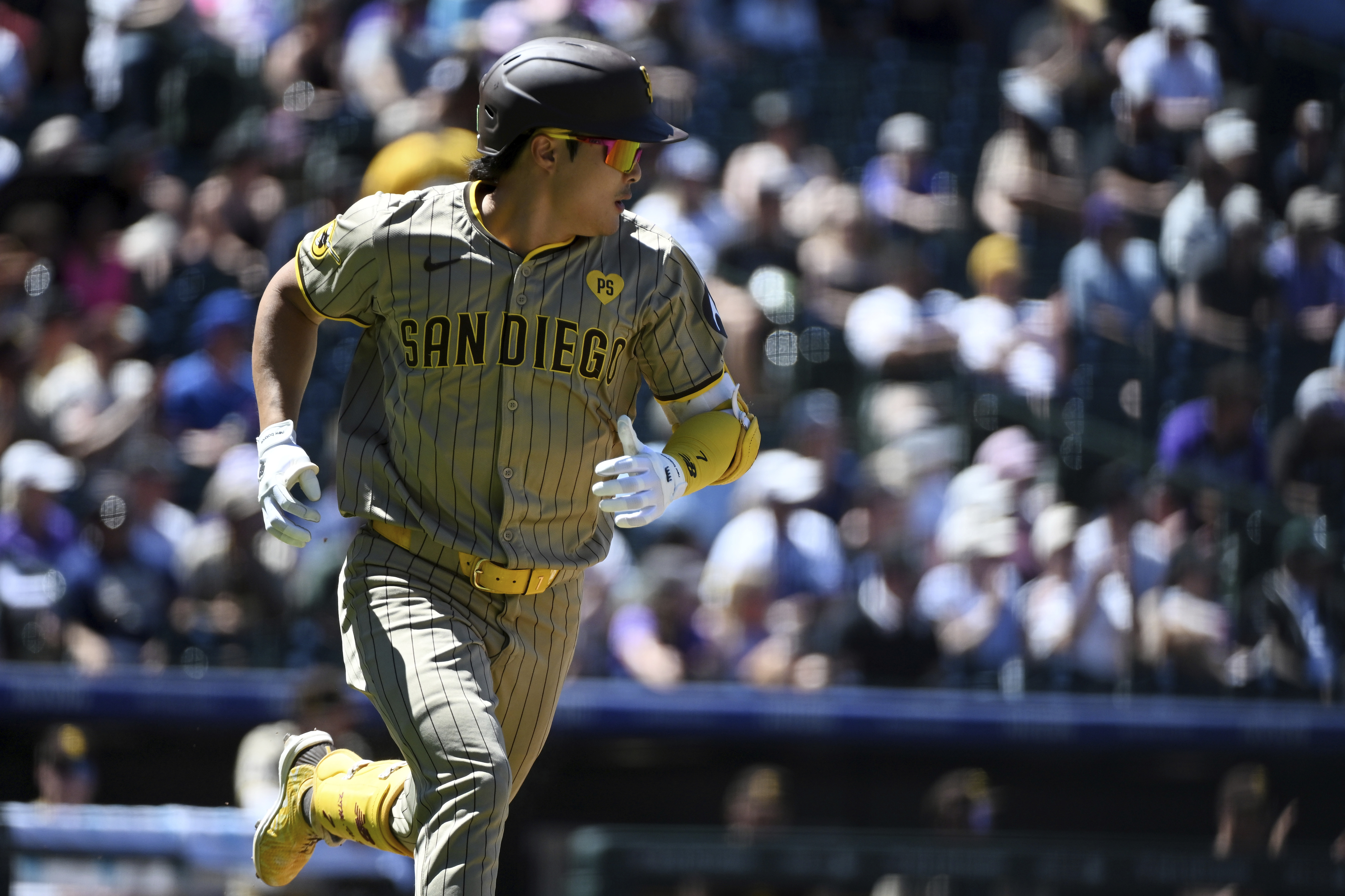 San Diego Padres' Ha-Seong Kim runs to first base after hitting a single in the third inning of a baseball game against the Colorado Rockies, Sunday, Aug. 18, 2024, in Denver. 