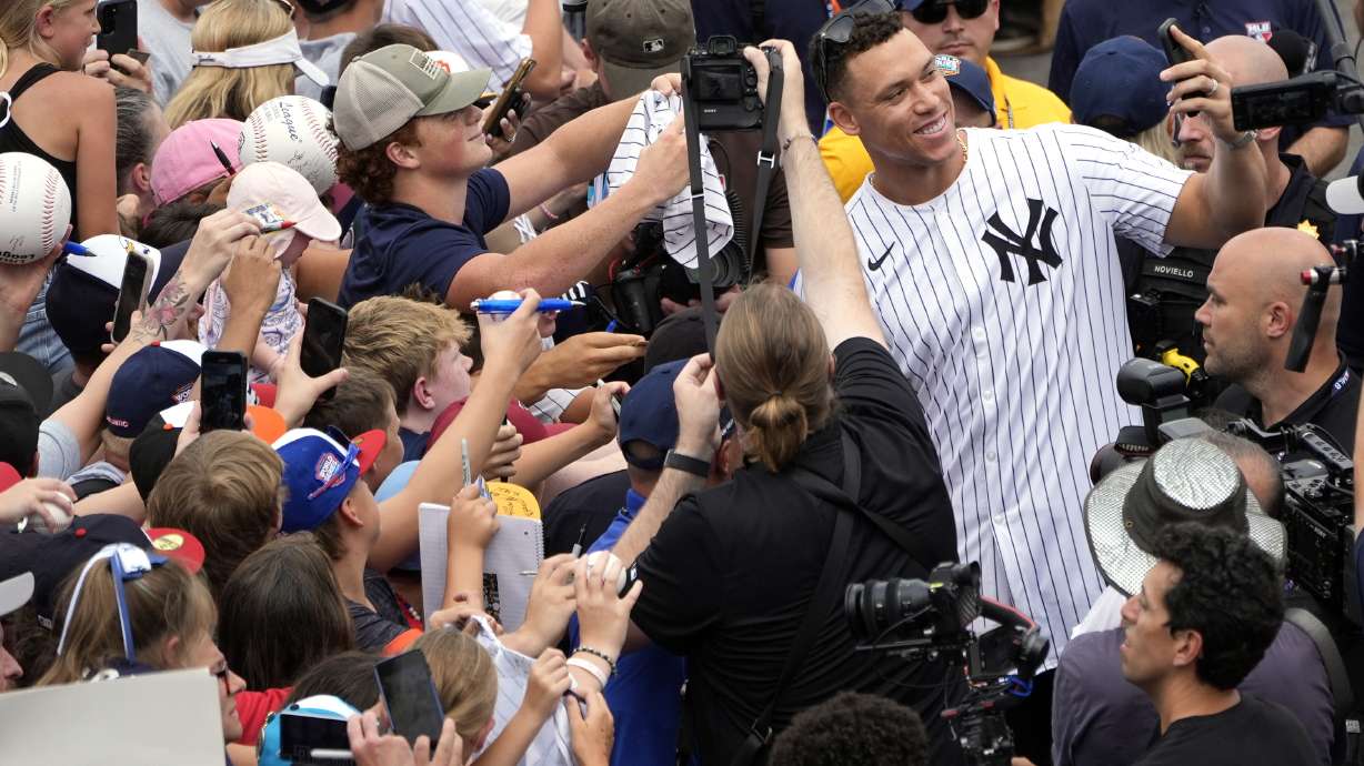 New York Yankees' Aaron Judge takes a selfie with a fan's cell phone as he arrives with the New York Yankees arrive at the Little League World Series Complex to watch the Little League World Series tournament in South Williamsport, Pa., Sunday, Aug. 18, 2024.