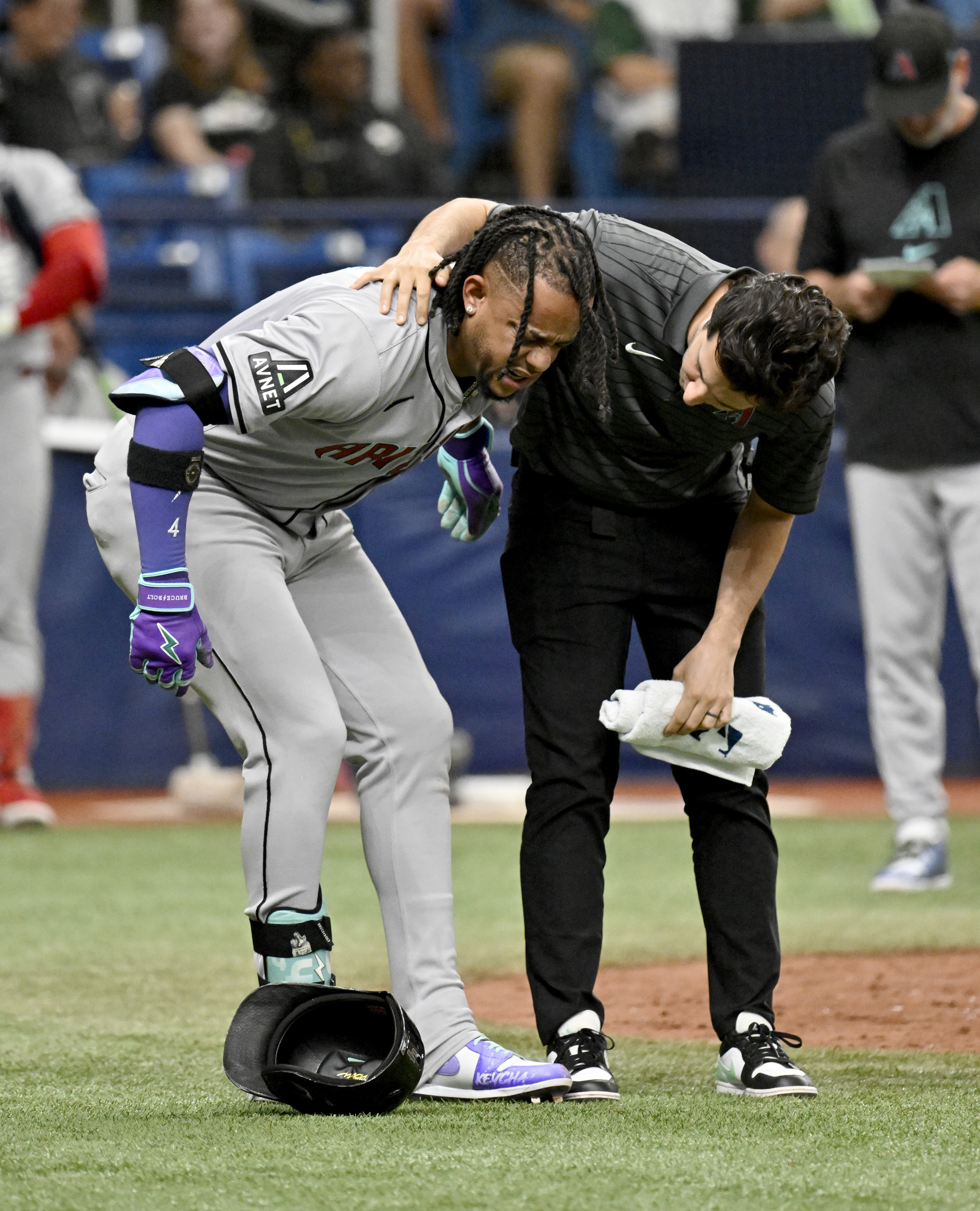 Arizona Diamondbacks Ketel Marte, left, is helped after being injured while batting during the 10th inning of a baseball game against the Tampa Bay Rays, Sunday, Aug. 18, 2024, in St. Petersburg, Fla. 