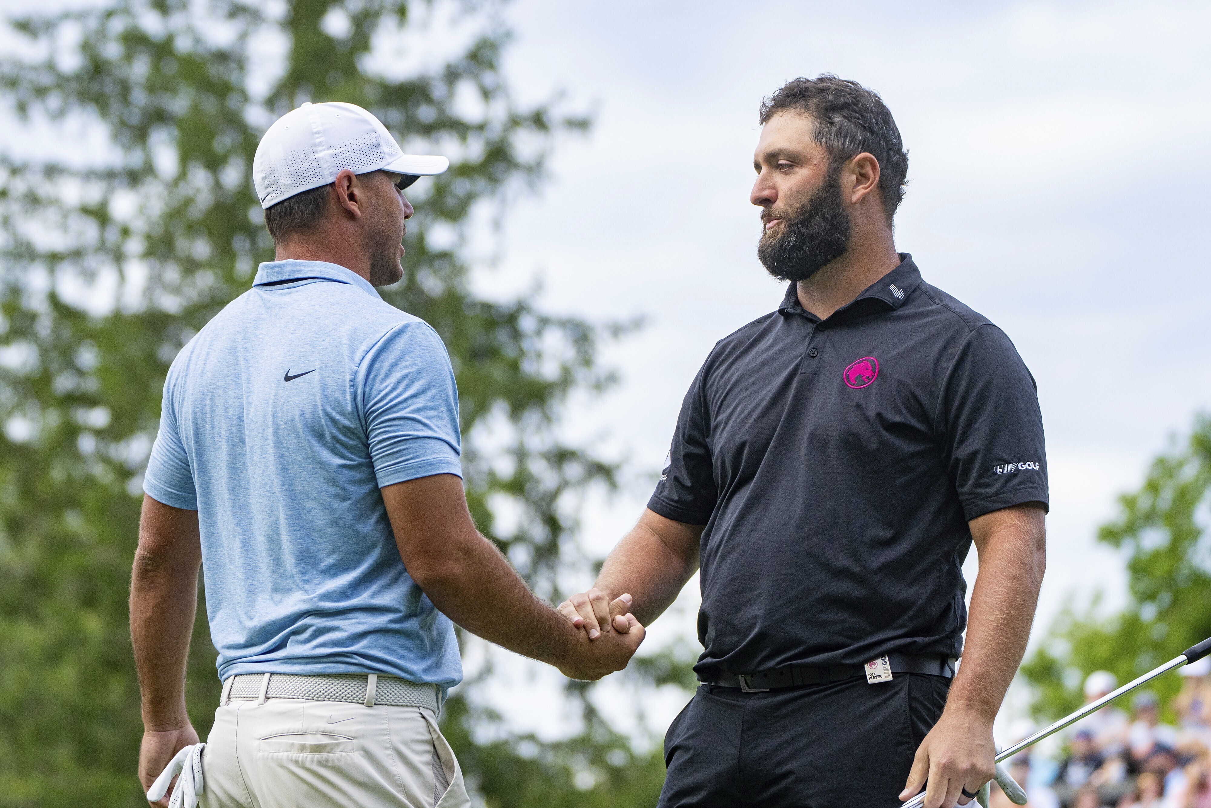Captain Brooks Koepka, left, of Smash GC, shakes hands with captain Jon Rahm, of Legion XIII, on the 18th green during the final round of LIV Golf Greenbrier at The Old White at The Greenbrier, Sunday, Aug. 18, 2024, in White Sulphur Springs, W.Va. 