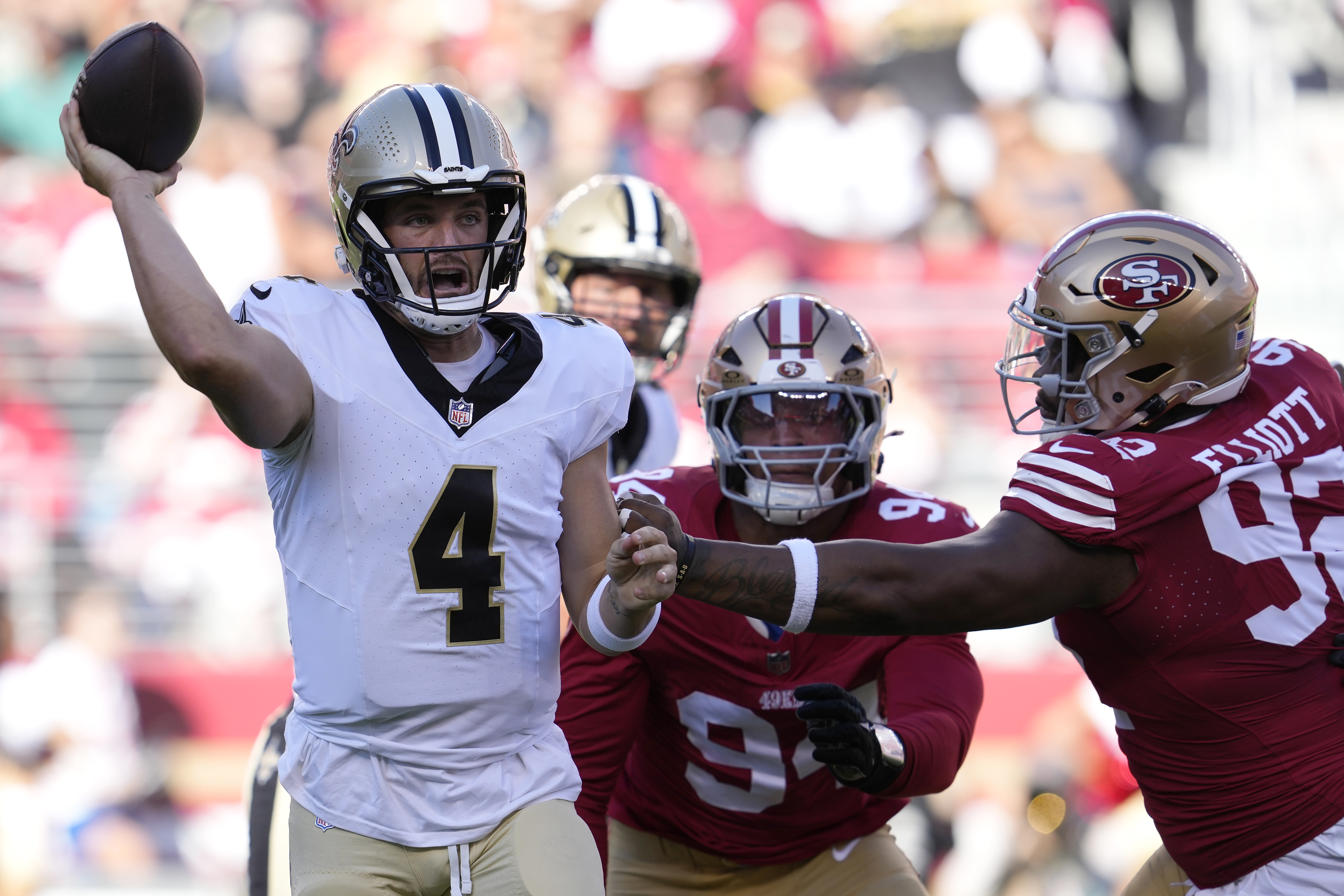 New Orleans Saints quarterback Derek Carr (4) passes as San Francisco 49ers defensive end Yetur Gross-Matos, middle, and defensive tackle Jordan Elliott apply pressure during the first half of a preseason NFL football game in Santa Clara, Calif., Sunday, Aug. 18, 2024. 