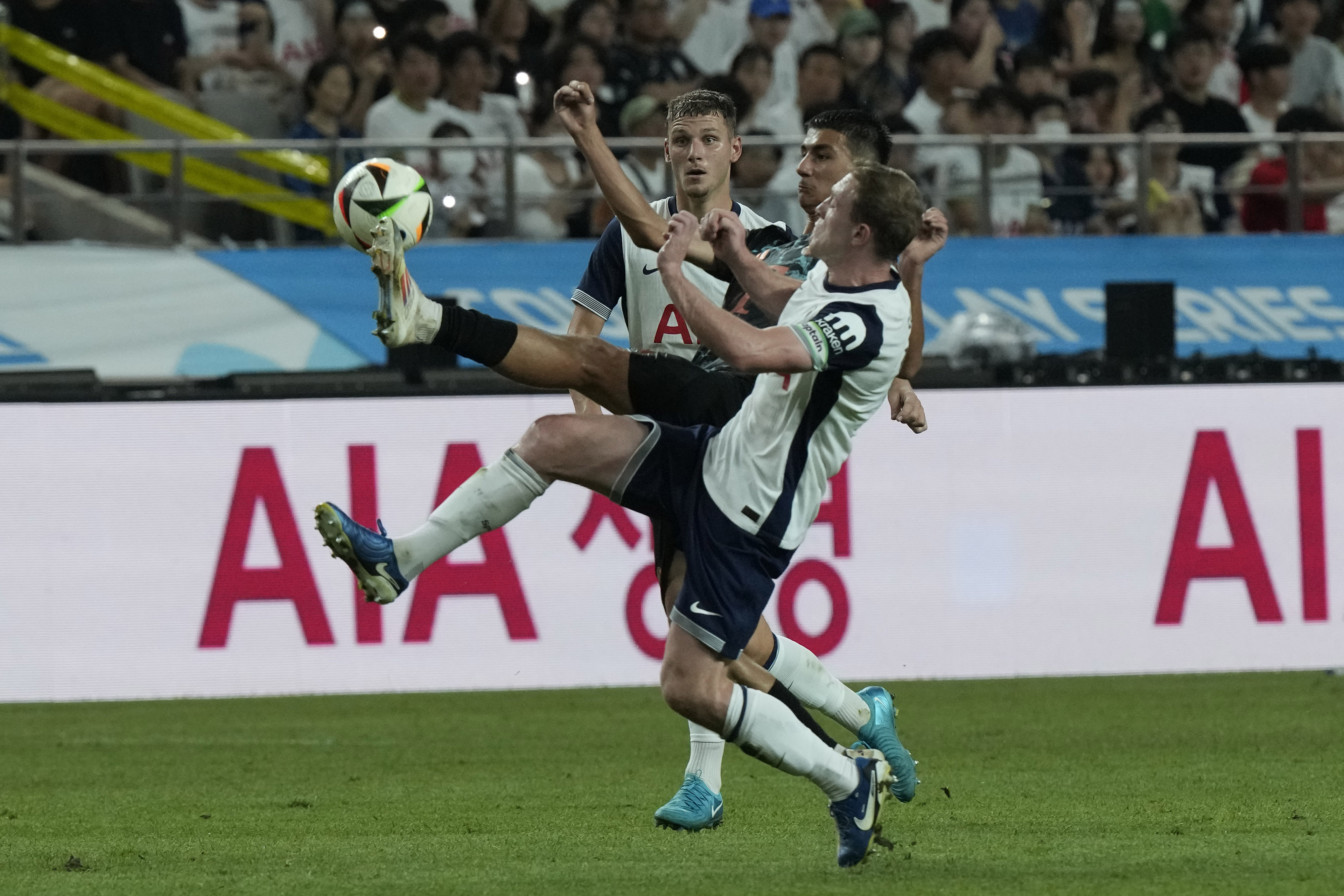 Bayern Munich's Adin Licina, center, fights for the ball with Tottenham Hotspur's Oliver Skipp, right, during a preseason soccer match at Seoul World Cup Stadium in Seoul, South Korea, Saturday, Aug. 3, 2024. 